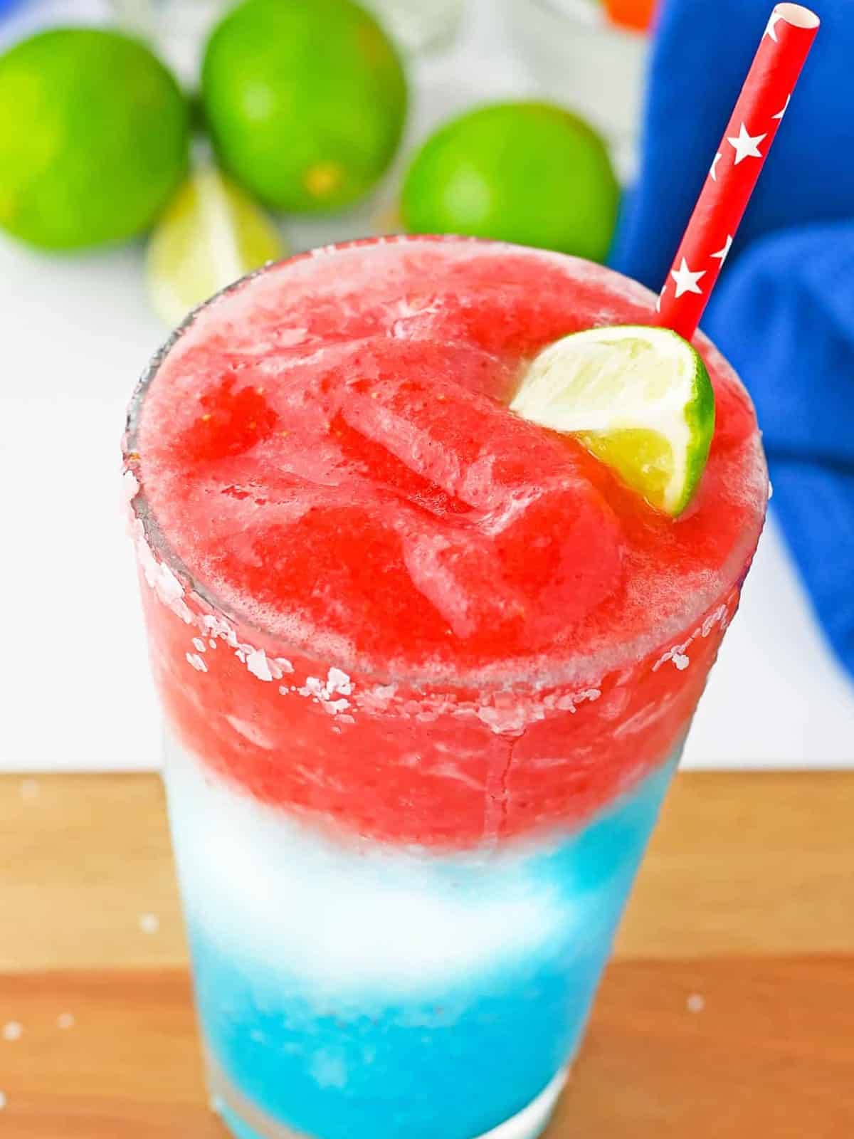 A finished layered red white and blue 4th of July margarita garnished with lime.