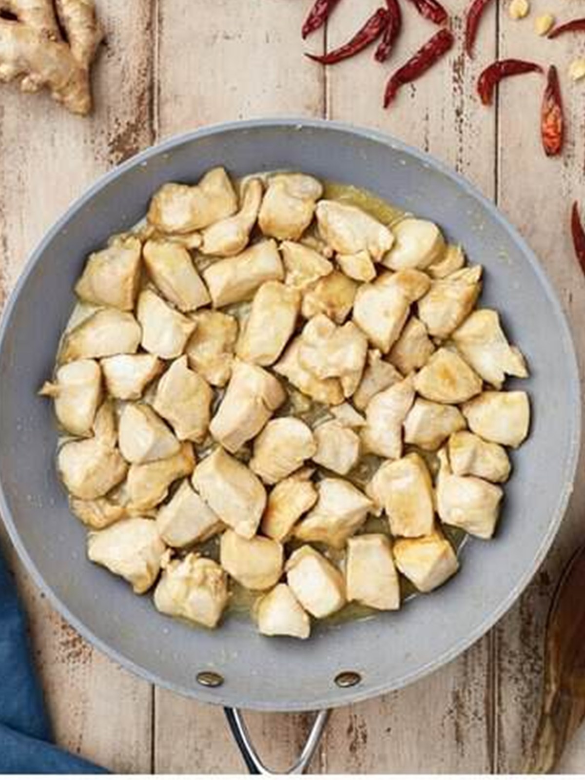 Chicken cooked until golden brown in a hot skillet for kung pao chicken.