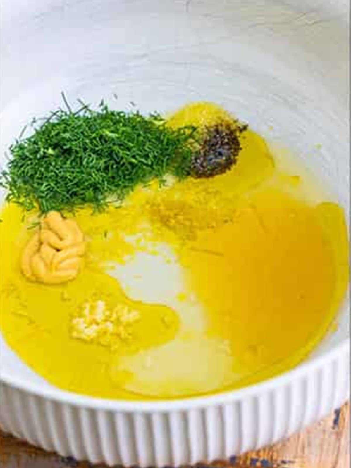 Olive oil, lemon, dill, honey, dijon, and garlic in a bowl for the dressing.