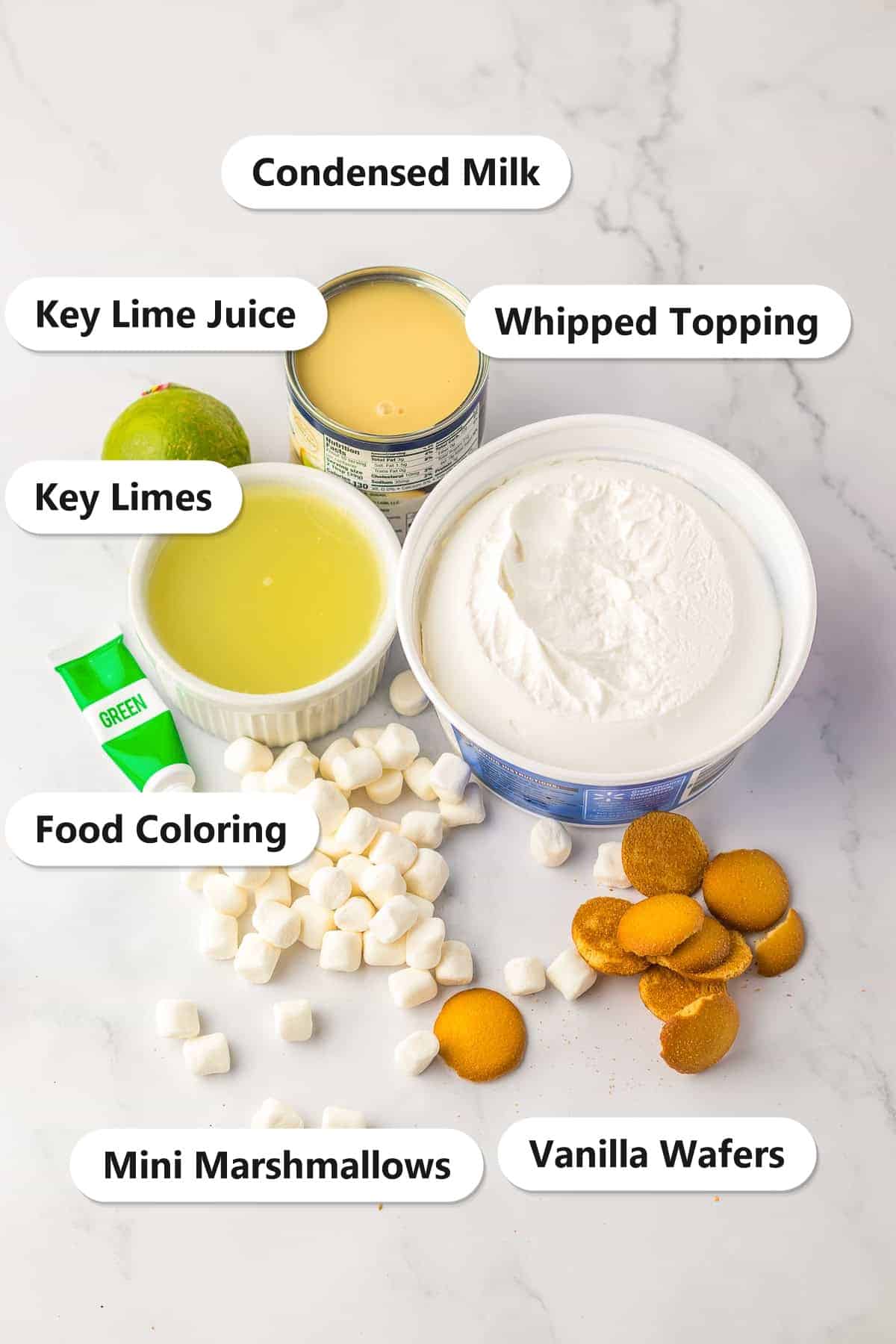 Ingredients to make Key Lime Fluff Salad laid out and labeled on a marble counter.