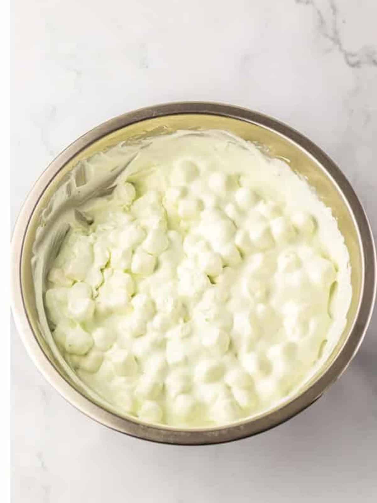 Pale green Key Lime Fluff Salad chilled and ready for vanilla wafer topping.