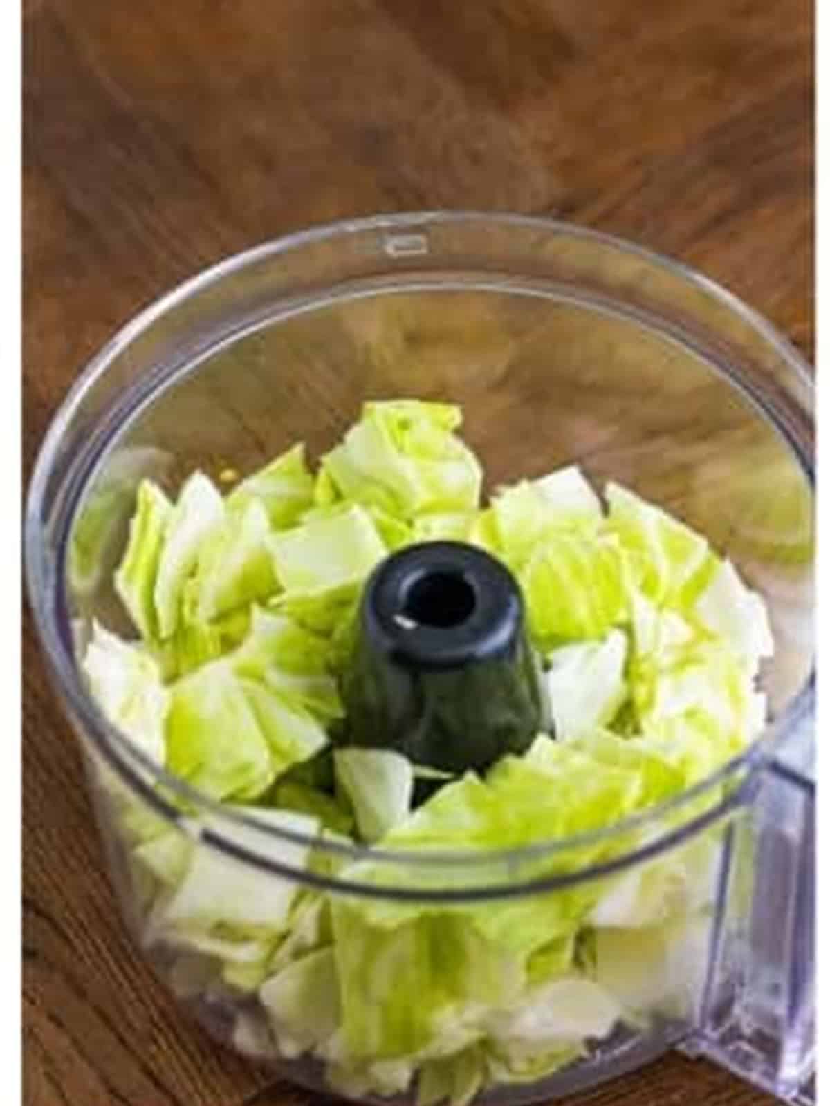 Diced cabbage in a food processor for coleslaw.