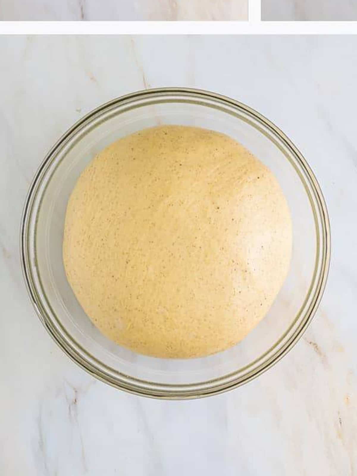 A smooth ball of risen king cake dough in a glass bowl.