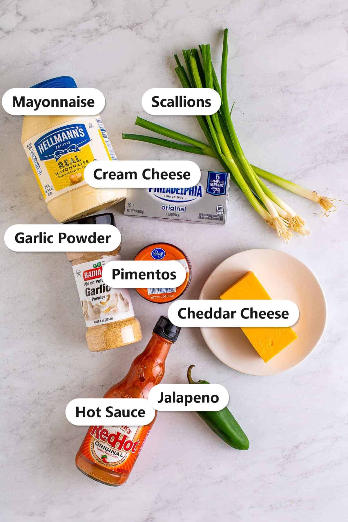 Labeled ingredients to make pimento cheese including cheddar, cream cheese, mayonnaise, pimentos, scallions, and jalapeno.