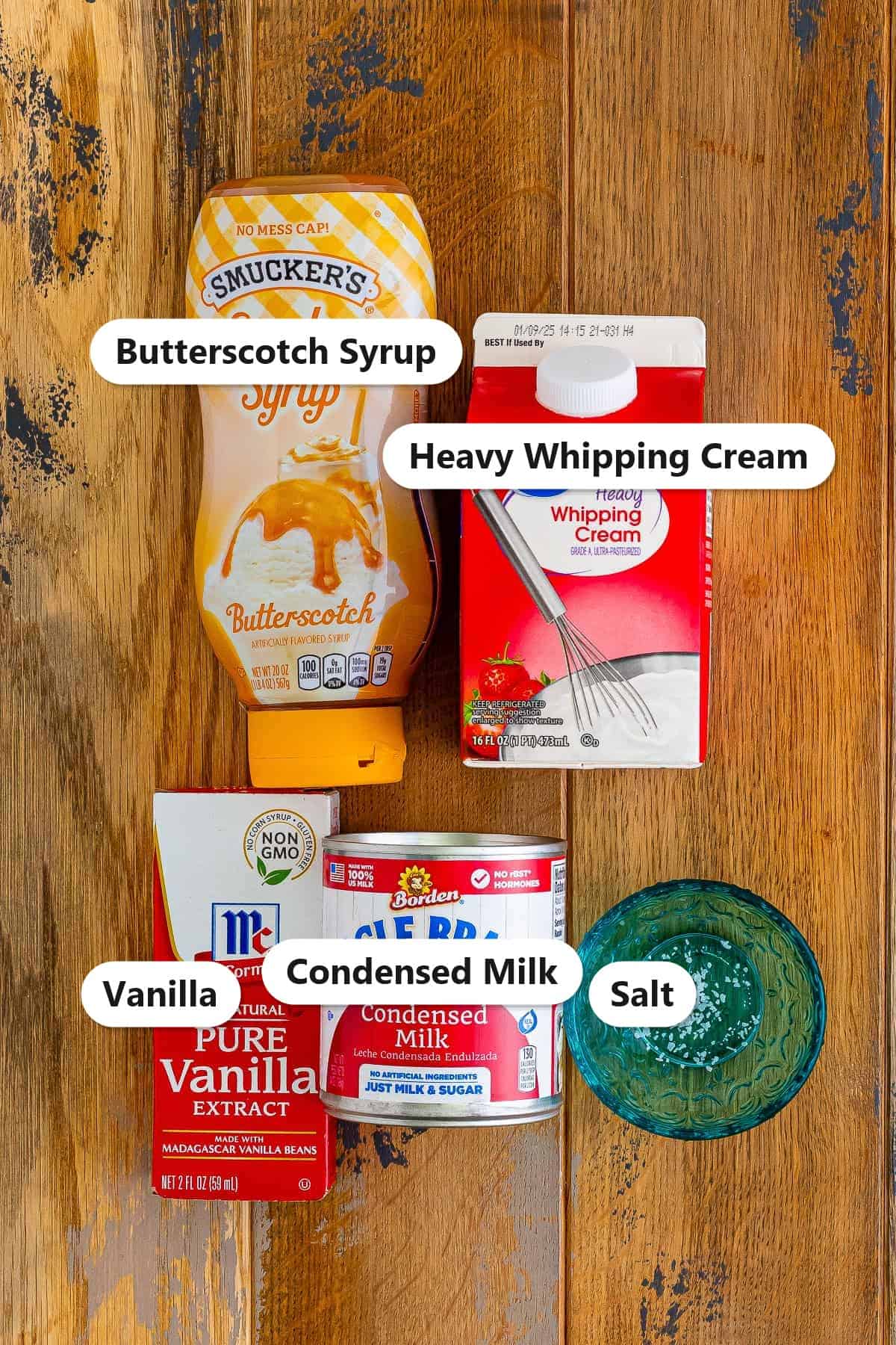 Labeled ingredients for no churn butterscotch ice cream including heavy whipping cream, sweetened condensed milk, butterscotch syrup, vanilla, and salt.