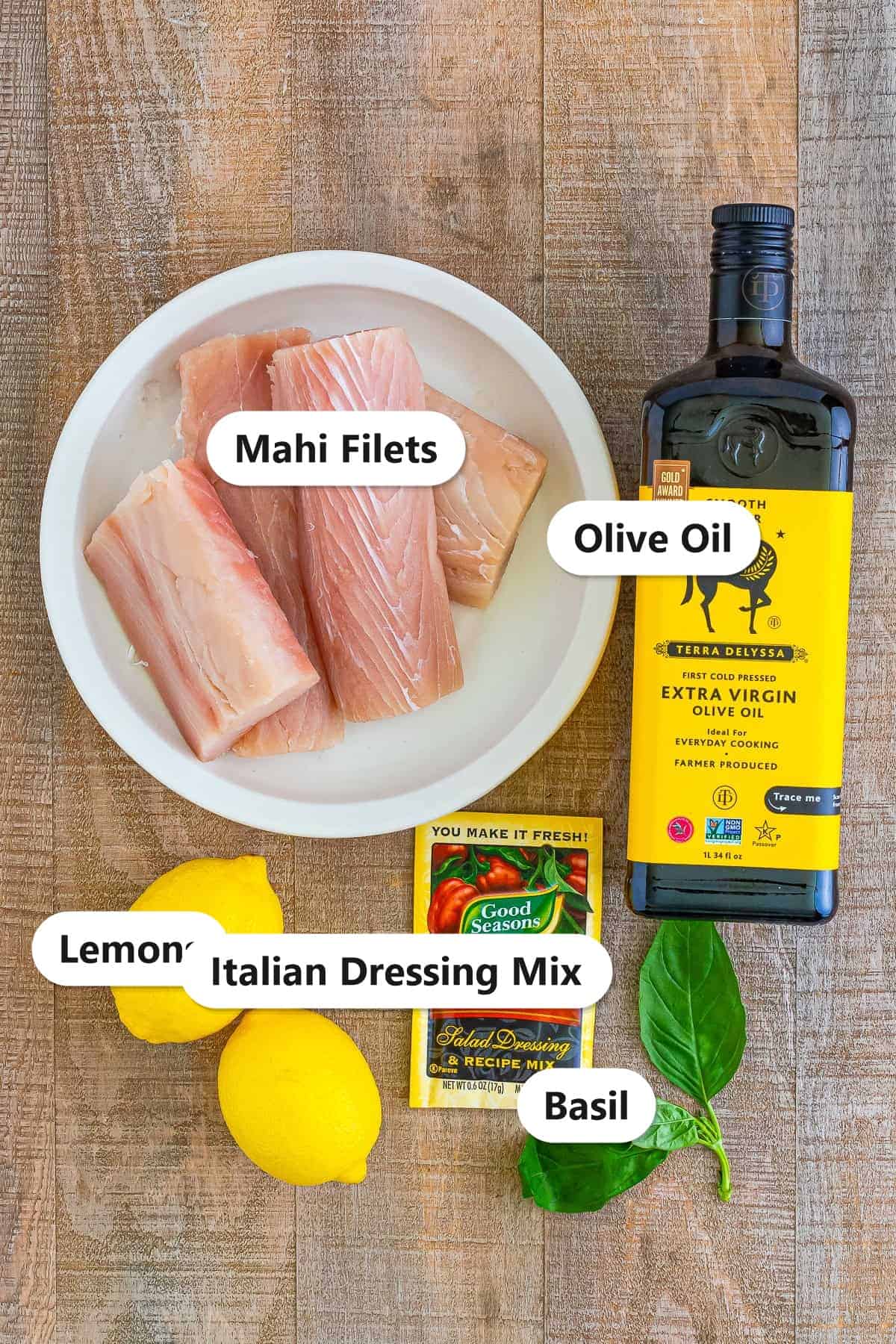 Labeled ingredients for Italian grilled mahi mahi including mahi filets, olive oil, lemons, Italian dressing mix, and basil.