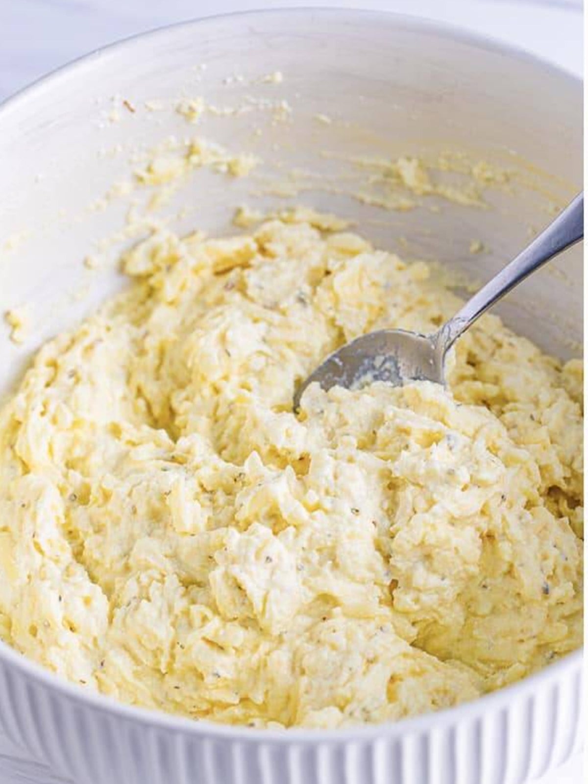 Ricotta cheese filling mixed with mozzarella, parmesan, and egg in a bowl.