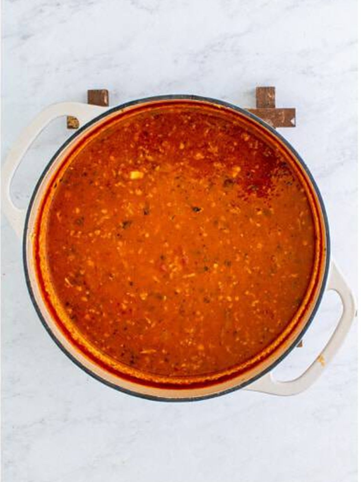 Simmered red tomato broth for Lasagna Soup in a Dutch oven.