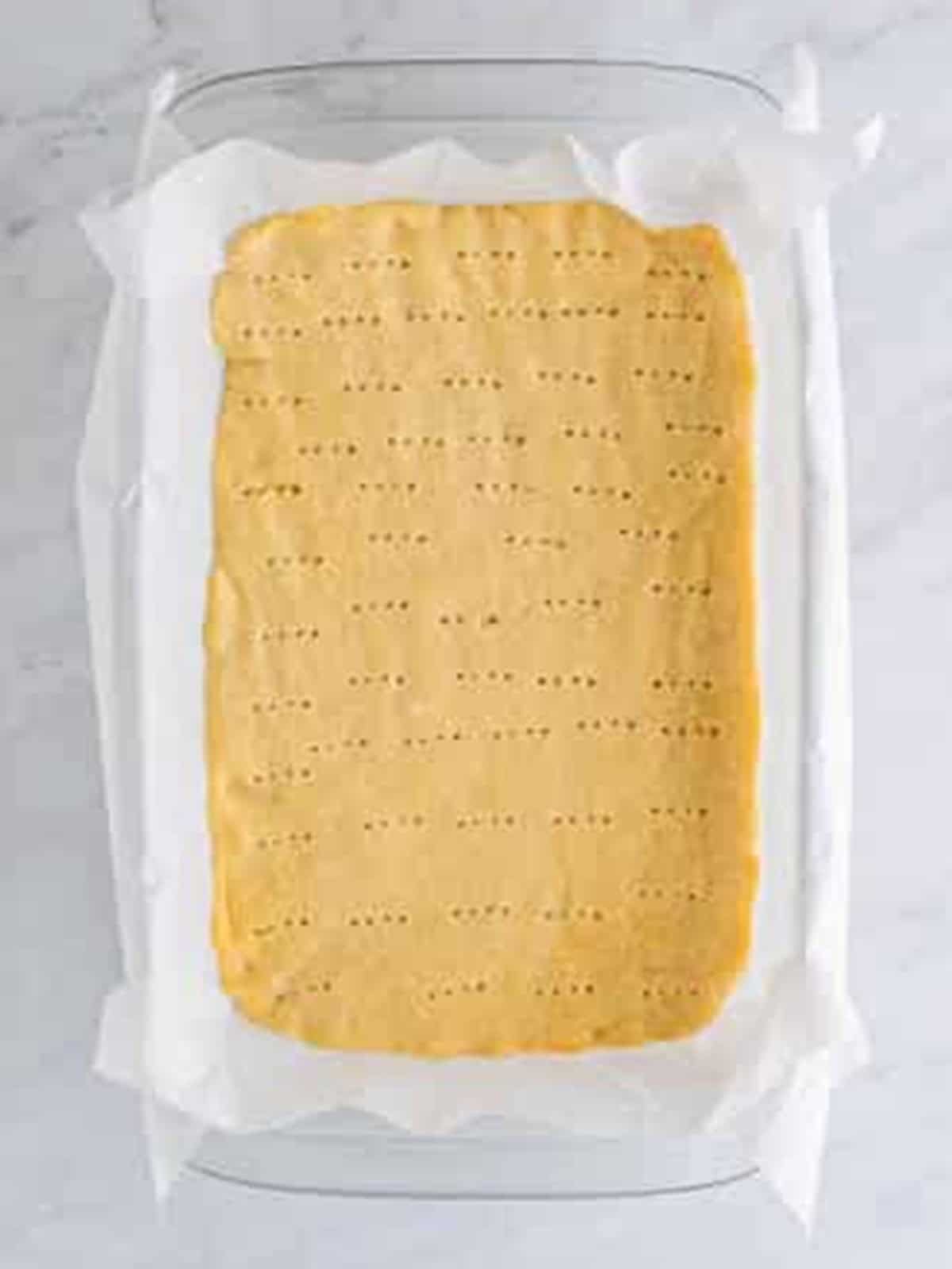 Baked lemon bar crust poked all over with a fork before adding the filling.