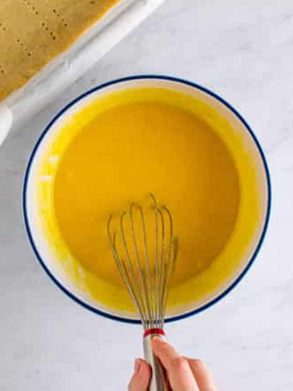 Bright yellow lemon bar filling whisked smooth in a bowl.