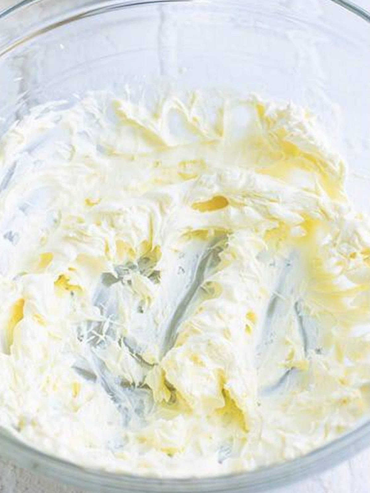 Cream cheese beaten until smooth and creamy in a glass mixing bowl.