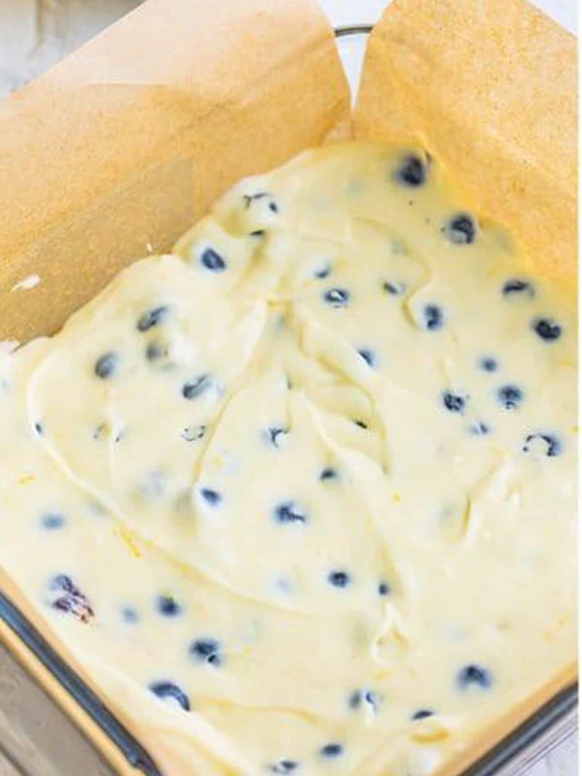 Lemon blueberry cheesecake batter poured over the Golden Oreo crust in the baking pan and topped with more blueberries.