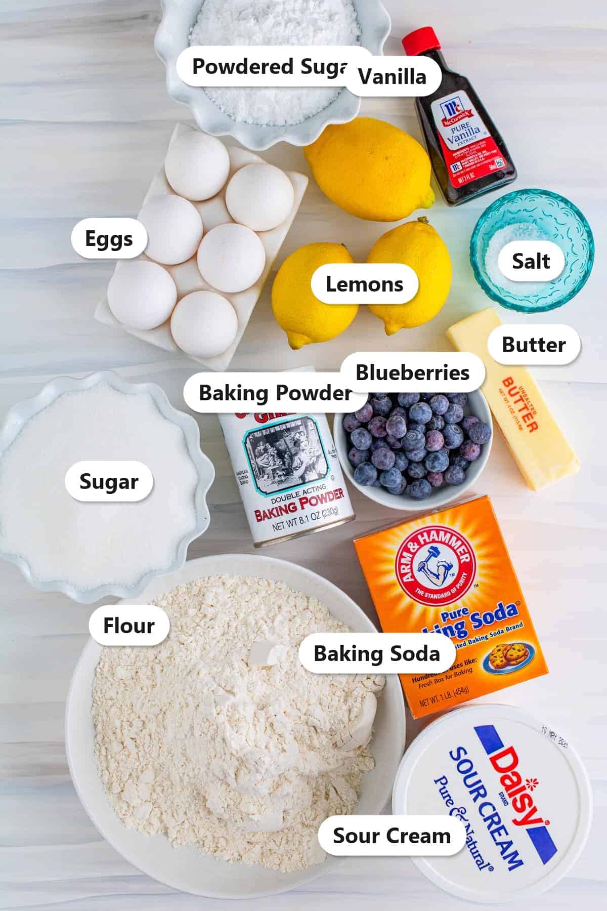 Labeled ingredients for lemon blueberry coffee cake including flour, sugar, eggs, lemons, blueberries, butter, sour cream, and leaveners.