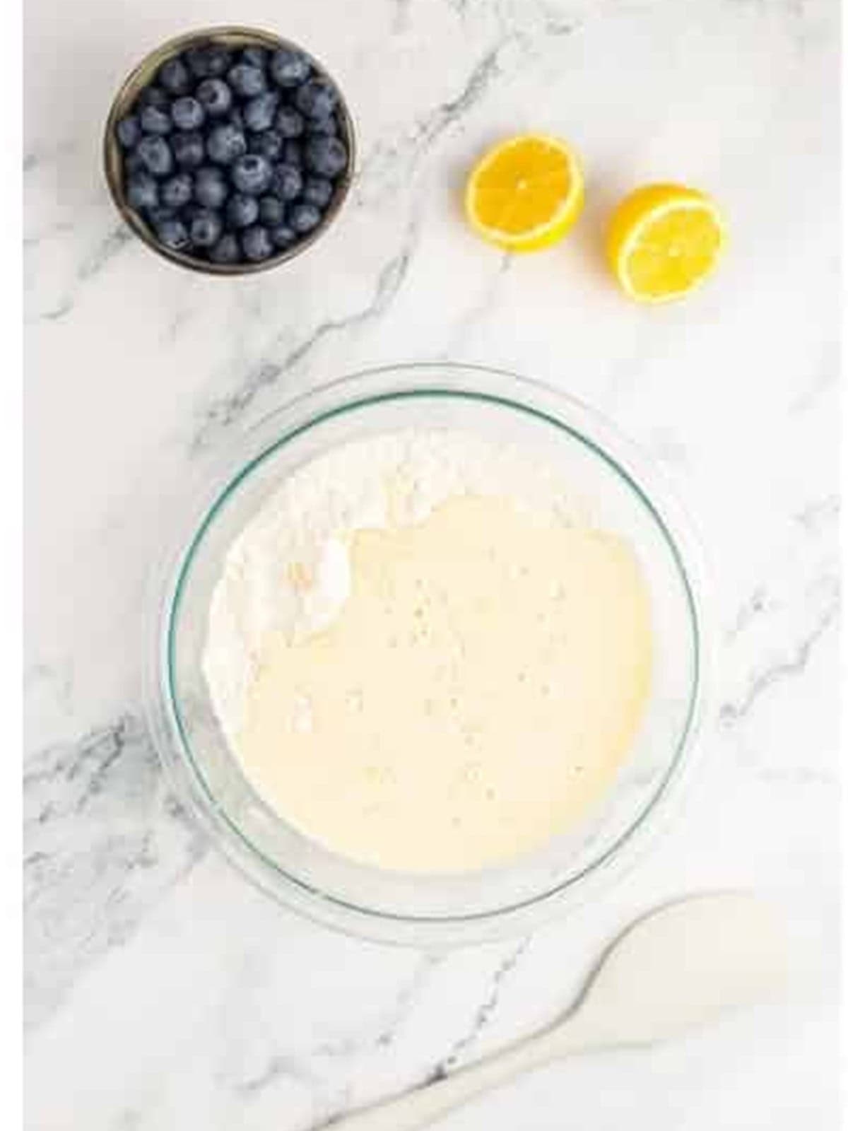 The lemon muffin batter mixed until just combined in a glass bowl.