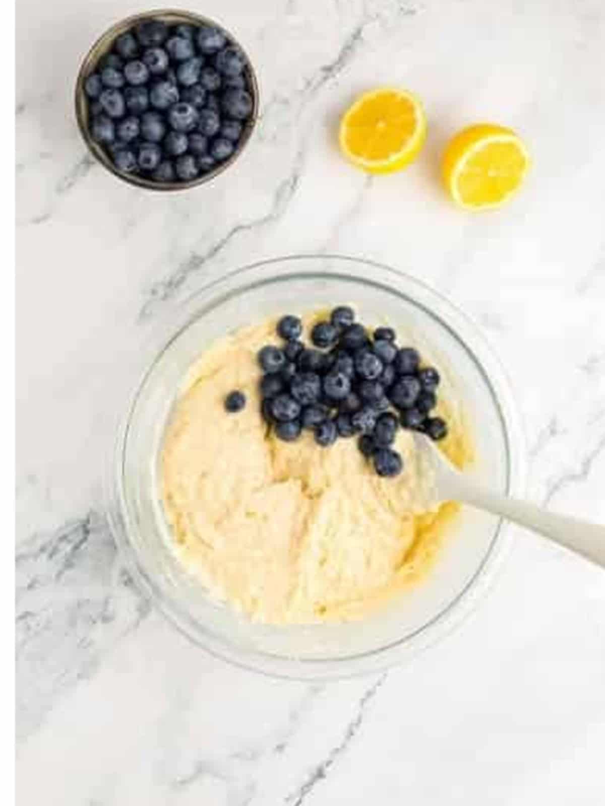 Folding fresh blueberries into the lemon muffin batter.