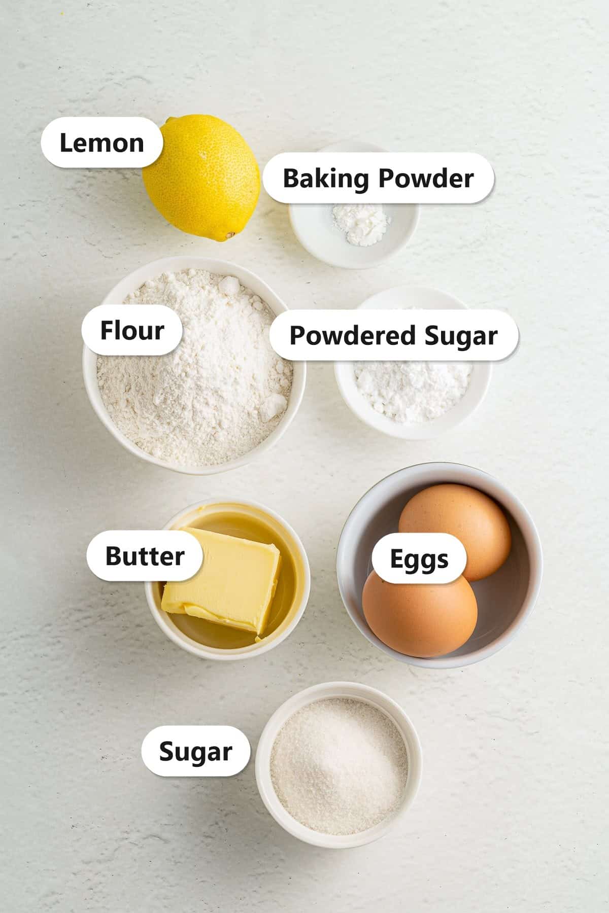 Labeled ingredients for lemon brownies including flour, butter, sugar, lemon, eggs, and powdered sugar.