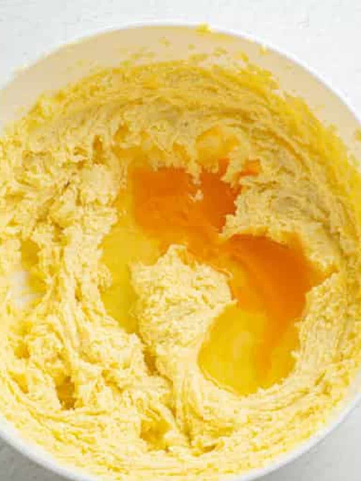 Adding eggs to the creamed butter and sugar for lemon brownie batter.