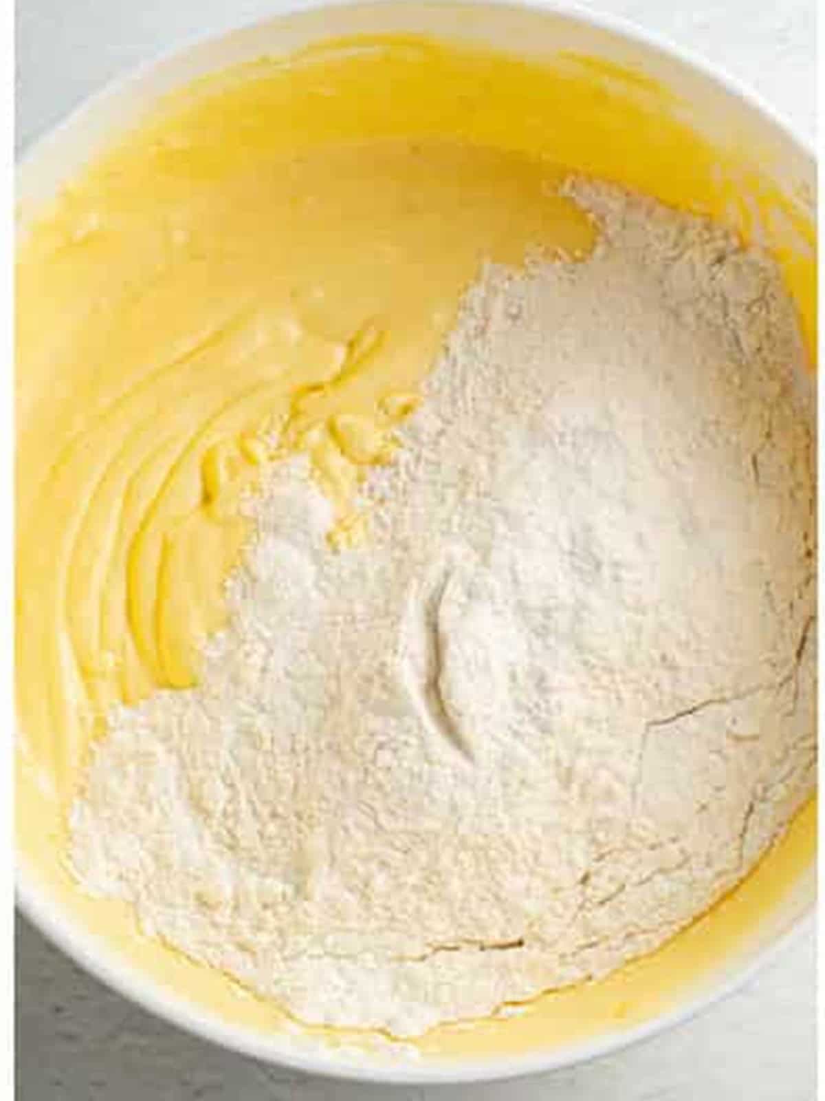 Mixing flour and baking powder into the lemon brownie batter.