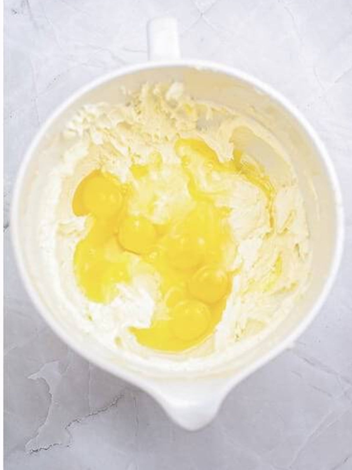 Adding eggs and lemon zest to the cake batter.