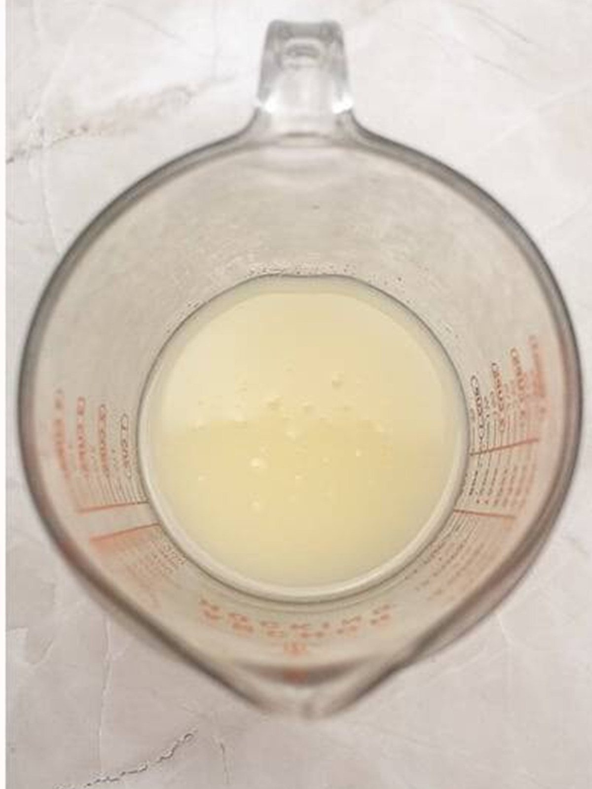 Lemon syrup in a measuring cup for the bundt cake.