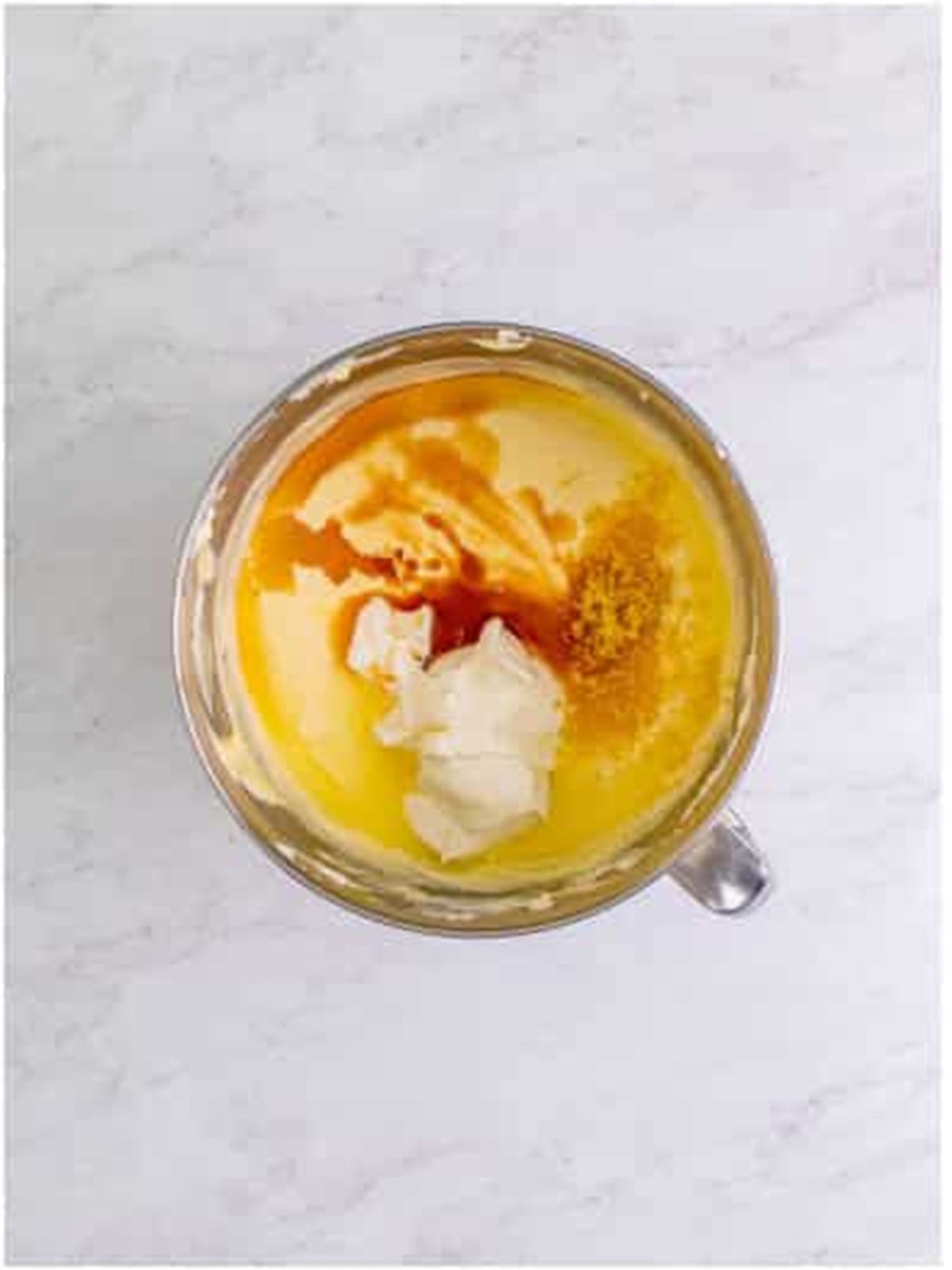 Adding sour cream, lemon juice, and zest to the cheesecake filling.