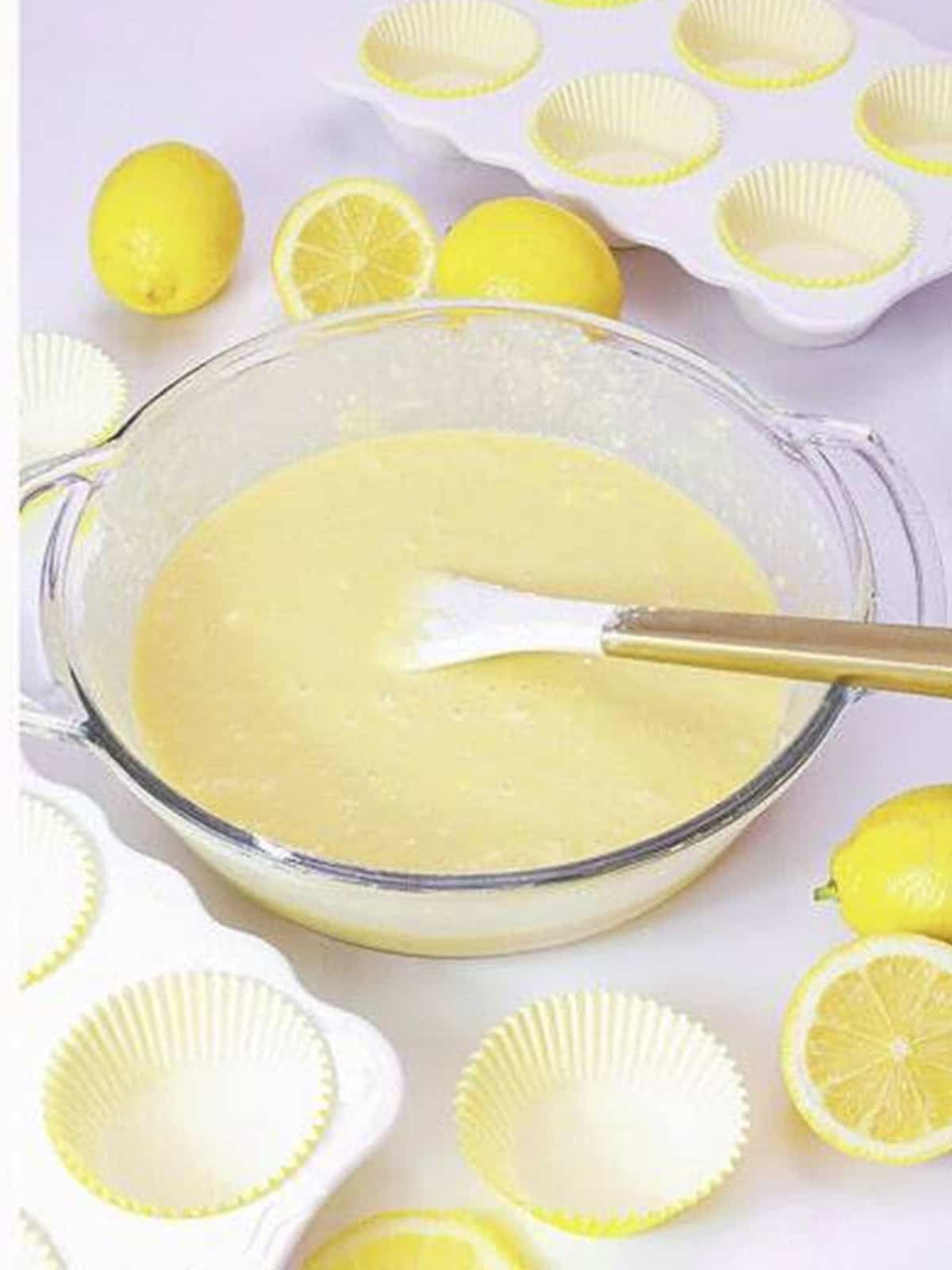 Smooth lemon cupcake batter ready beside paper liners.