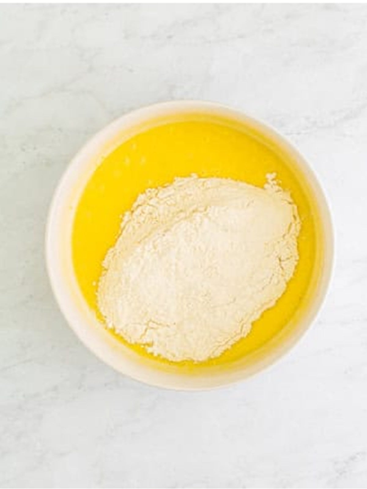 Stirring the dry ingredients into the lemon cupcake batter.