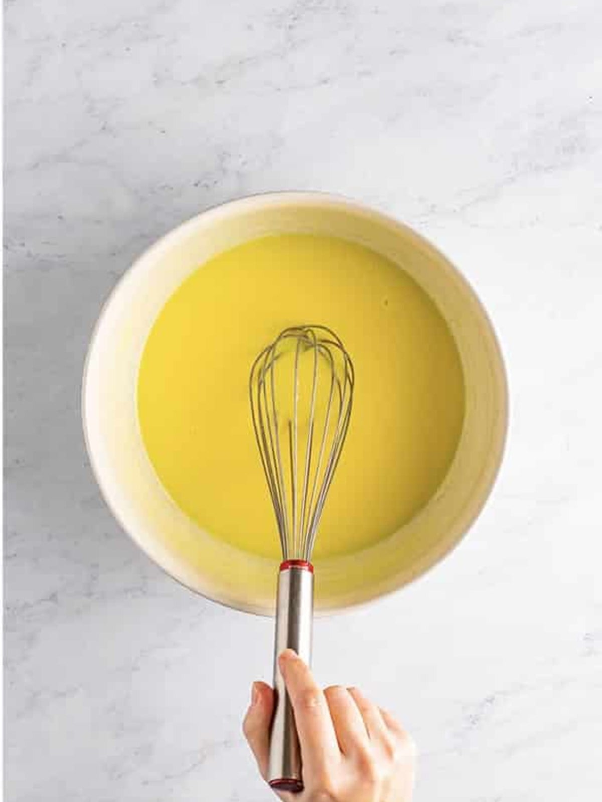 Instant lemon pudding and milk being whisked together in a bowl for lemon pudding shots.