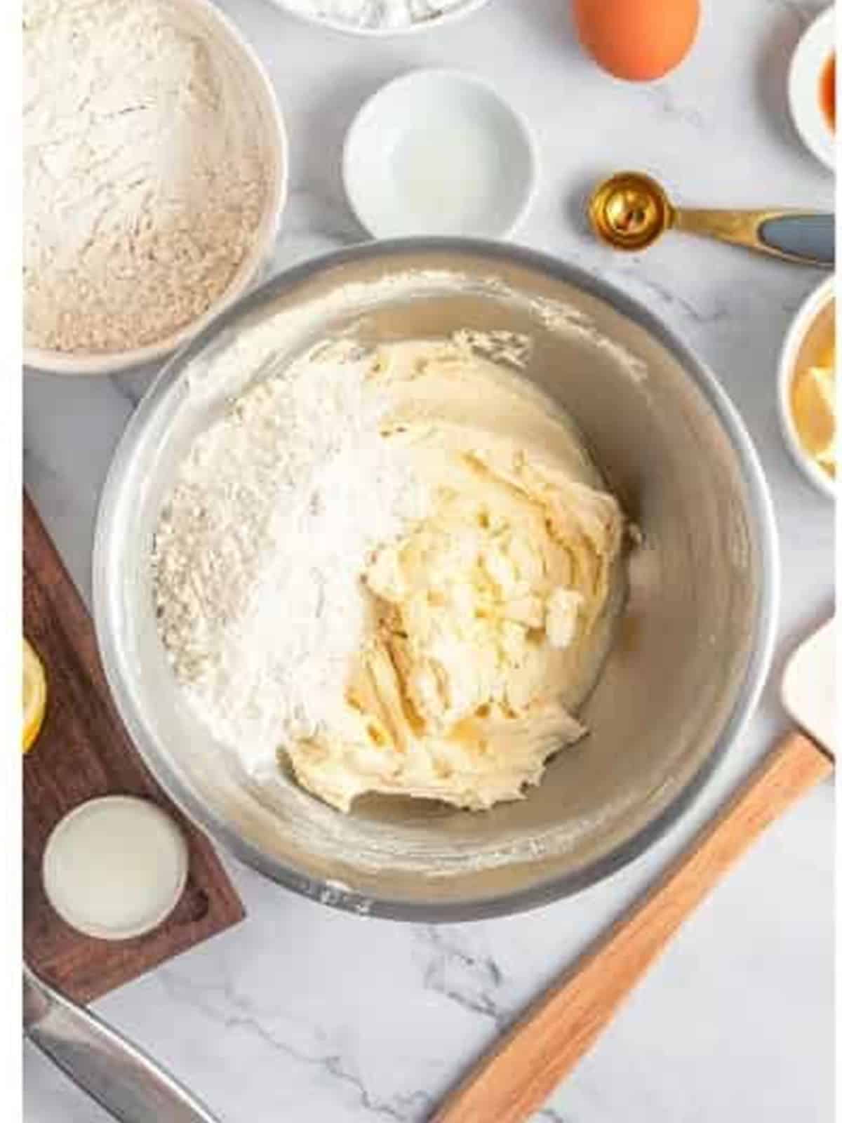 Flour added to the lemon cookie dough in a bowl.