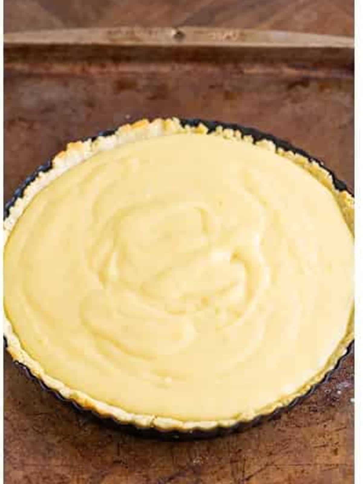 Lemonade tart filling spread into the par-baked tart crust.