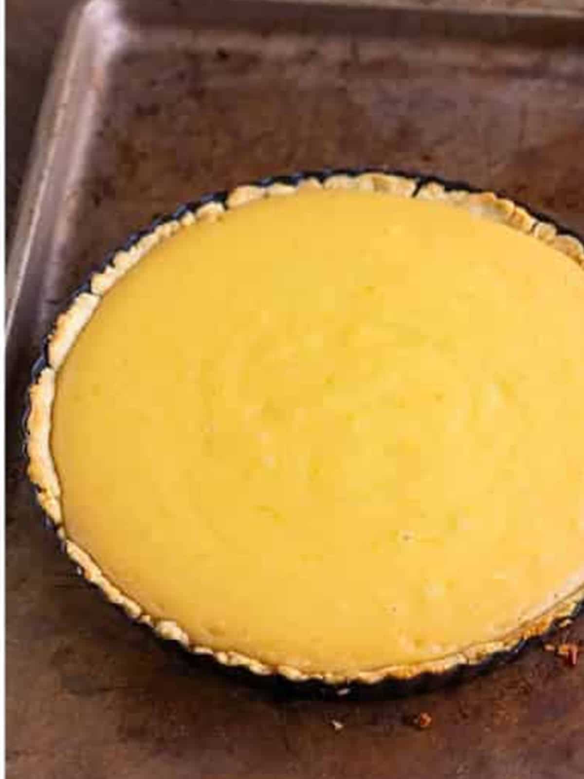 Baked lemonade tart with a set, golden lemon filling.
