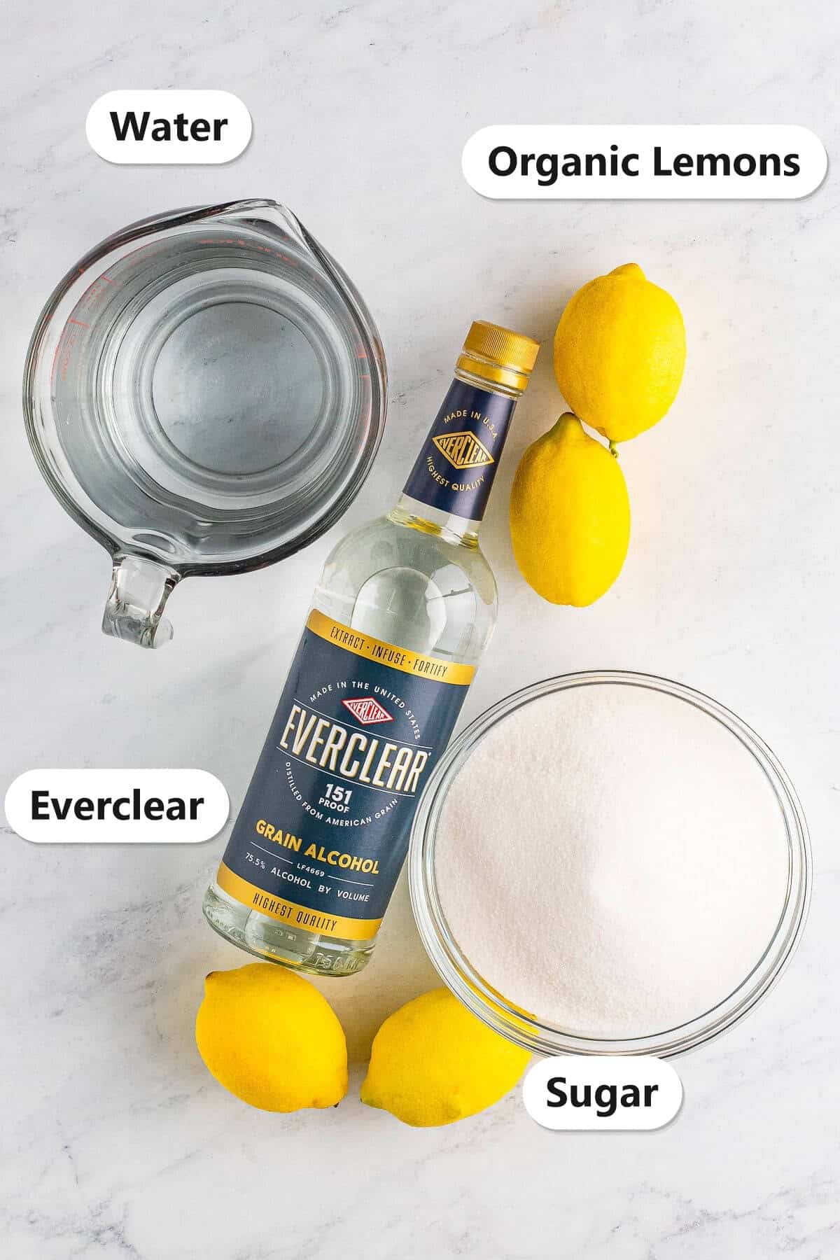 Labeled ingredients for limoncello recipe including organic lemons, Everclear grain alcohol, water, and sugar.