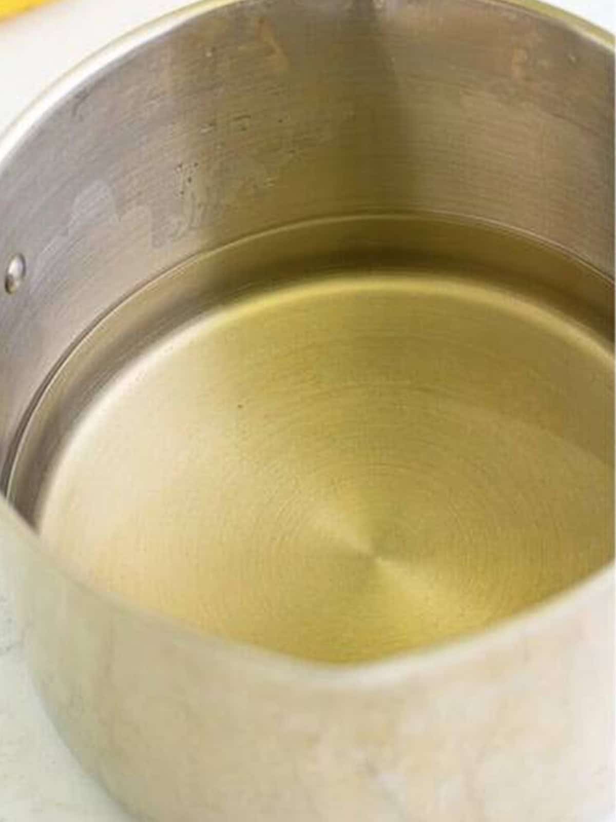 Simple syrup of water and sugar dissolving in a saucepan for limoncello recipe.