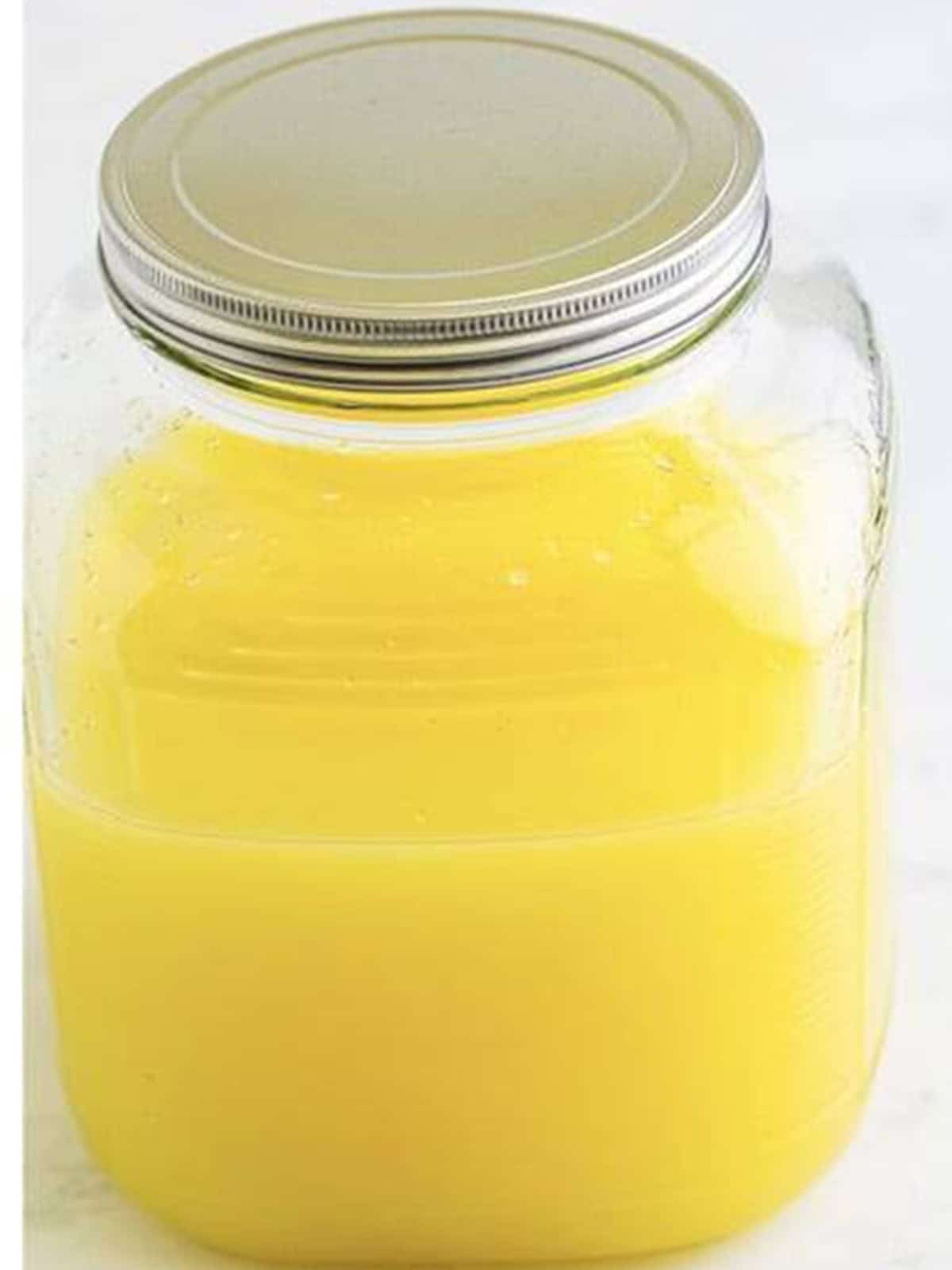 Finished homemade limoncello in a glass jar ready to chill.