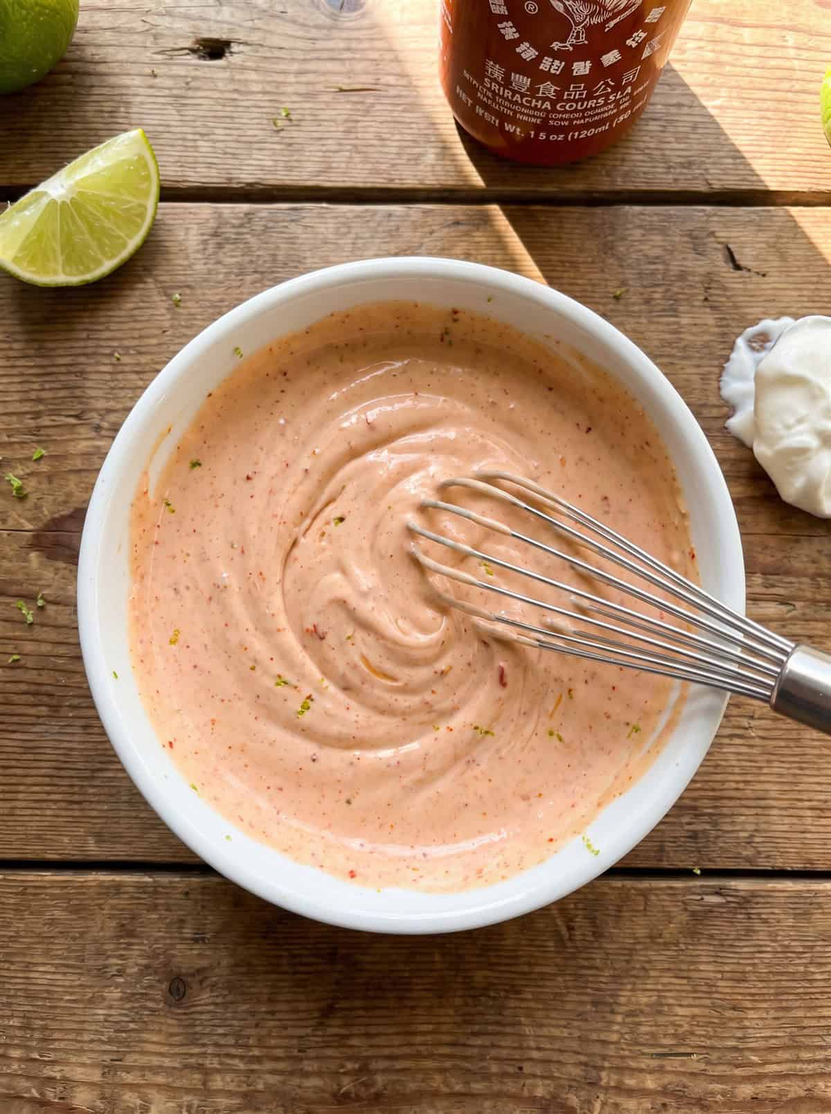 Sriracha lime sour cream whisked in a bowl.
