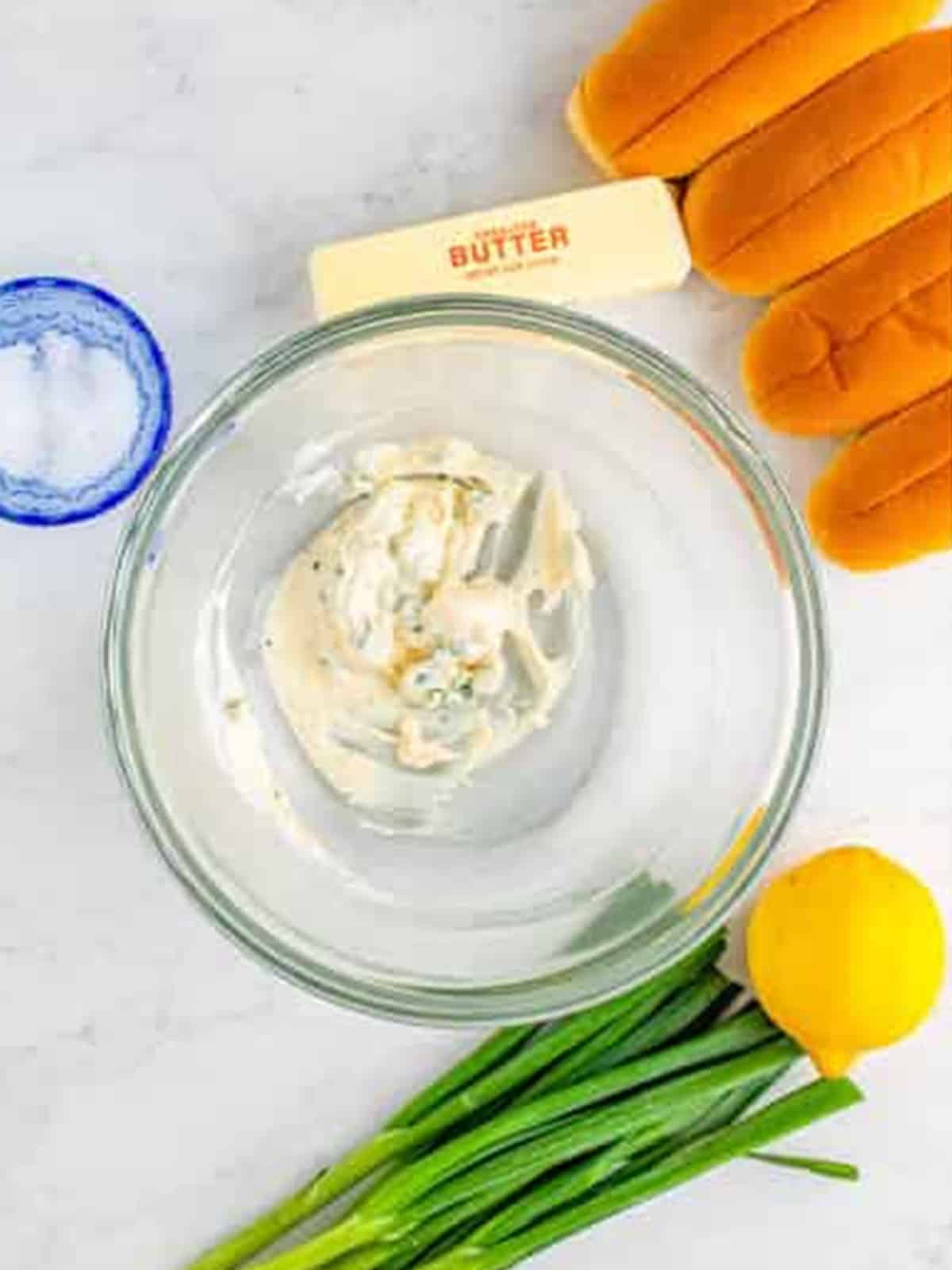 Lobster roll dressing whisked smooth in a glass bowl.