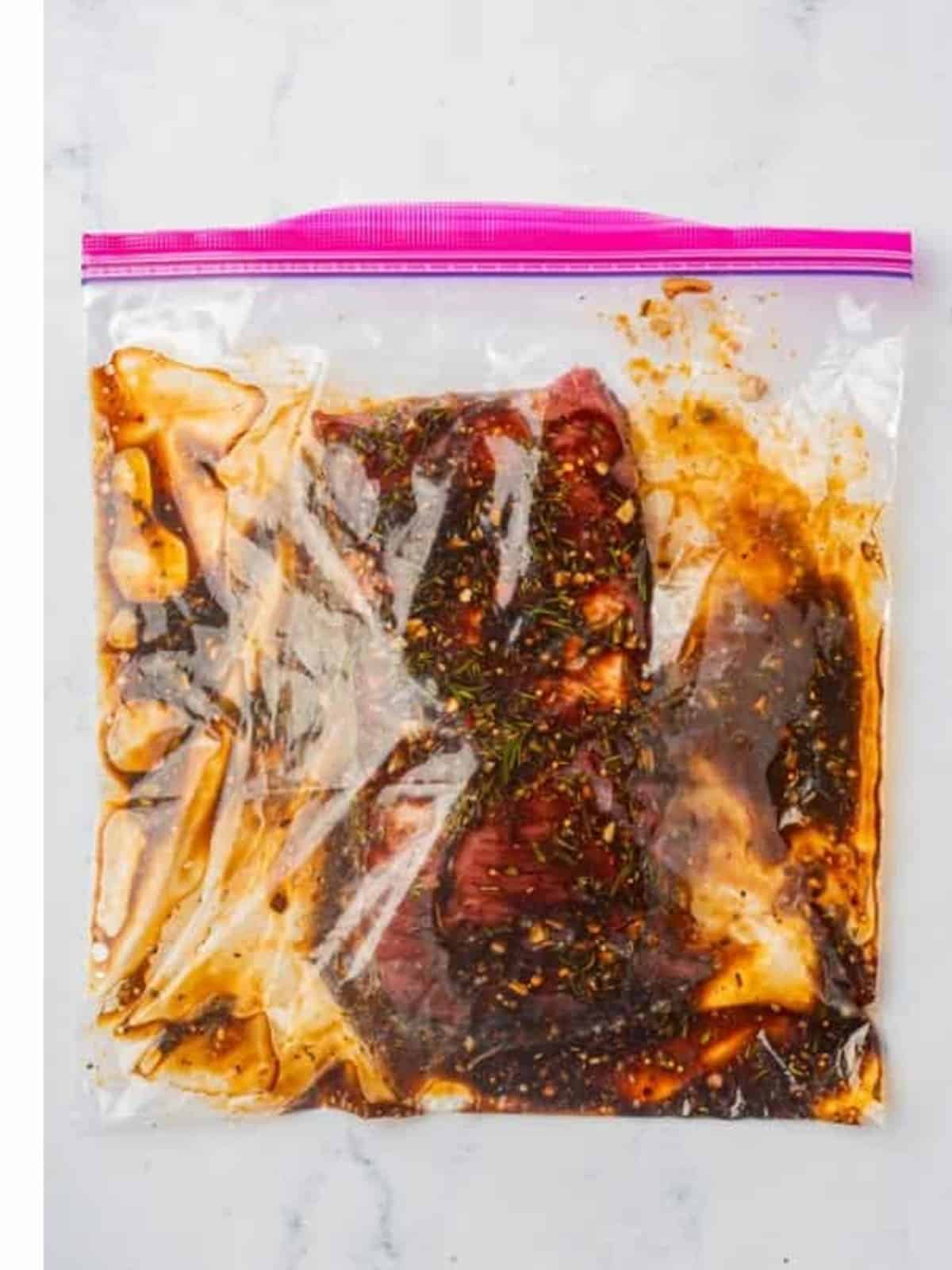 London broil marinating in a resealable bag with the balsamic herb marinade.