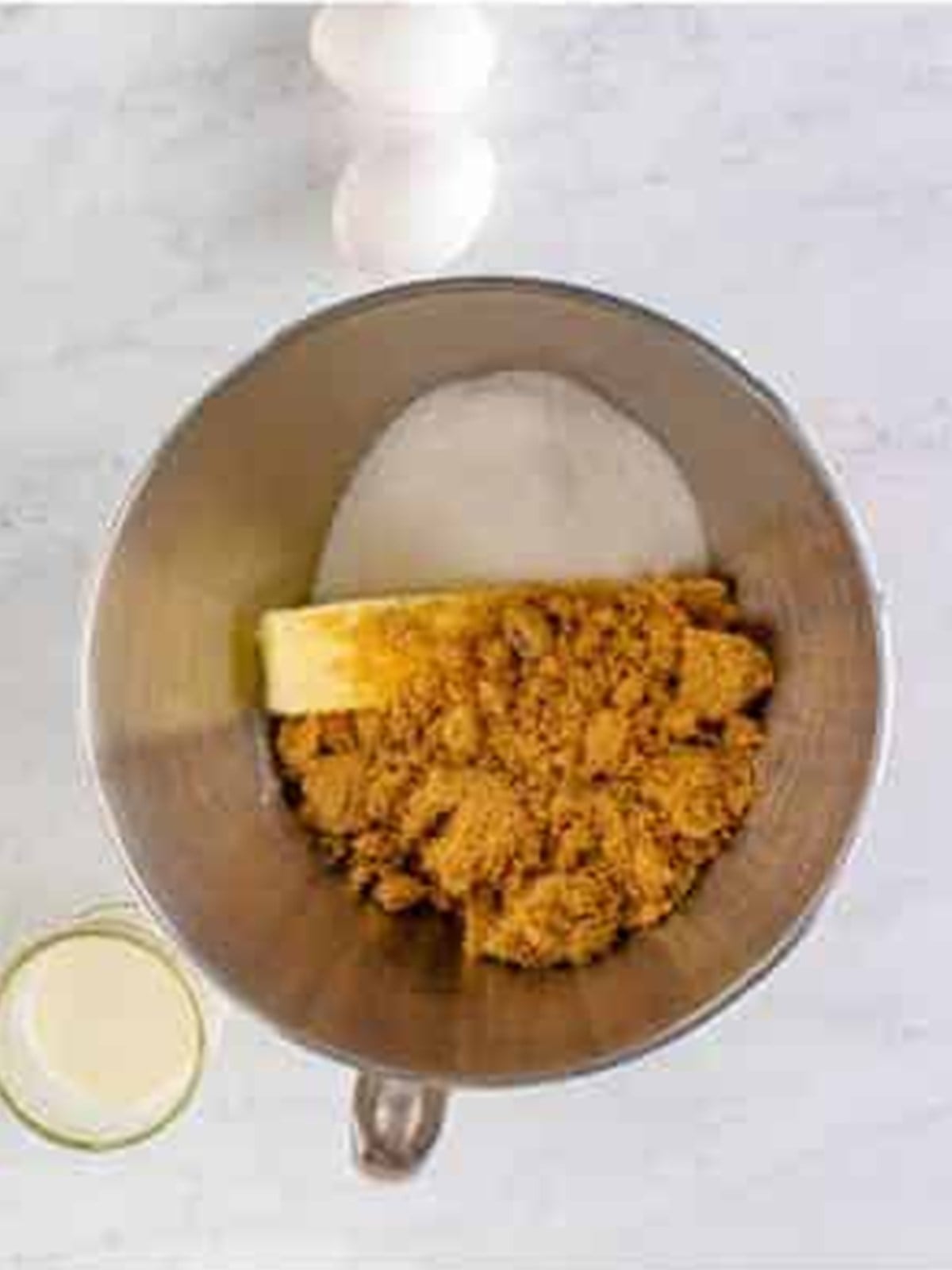 Butter, brown sugar, and granulated sugar creaming together in a stand mixer.