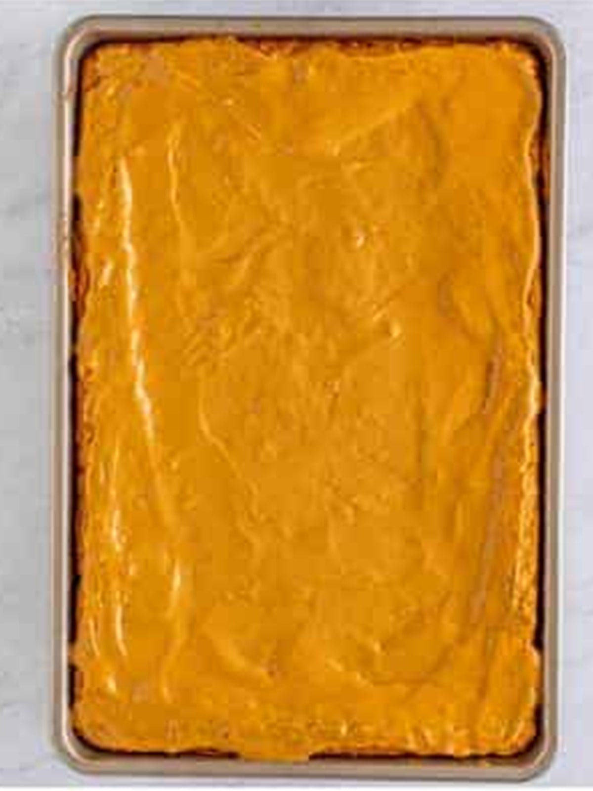 A layer of peanut butter spread over the warm baked peanut butter bars.