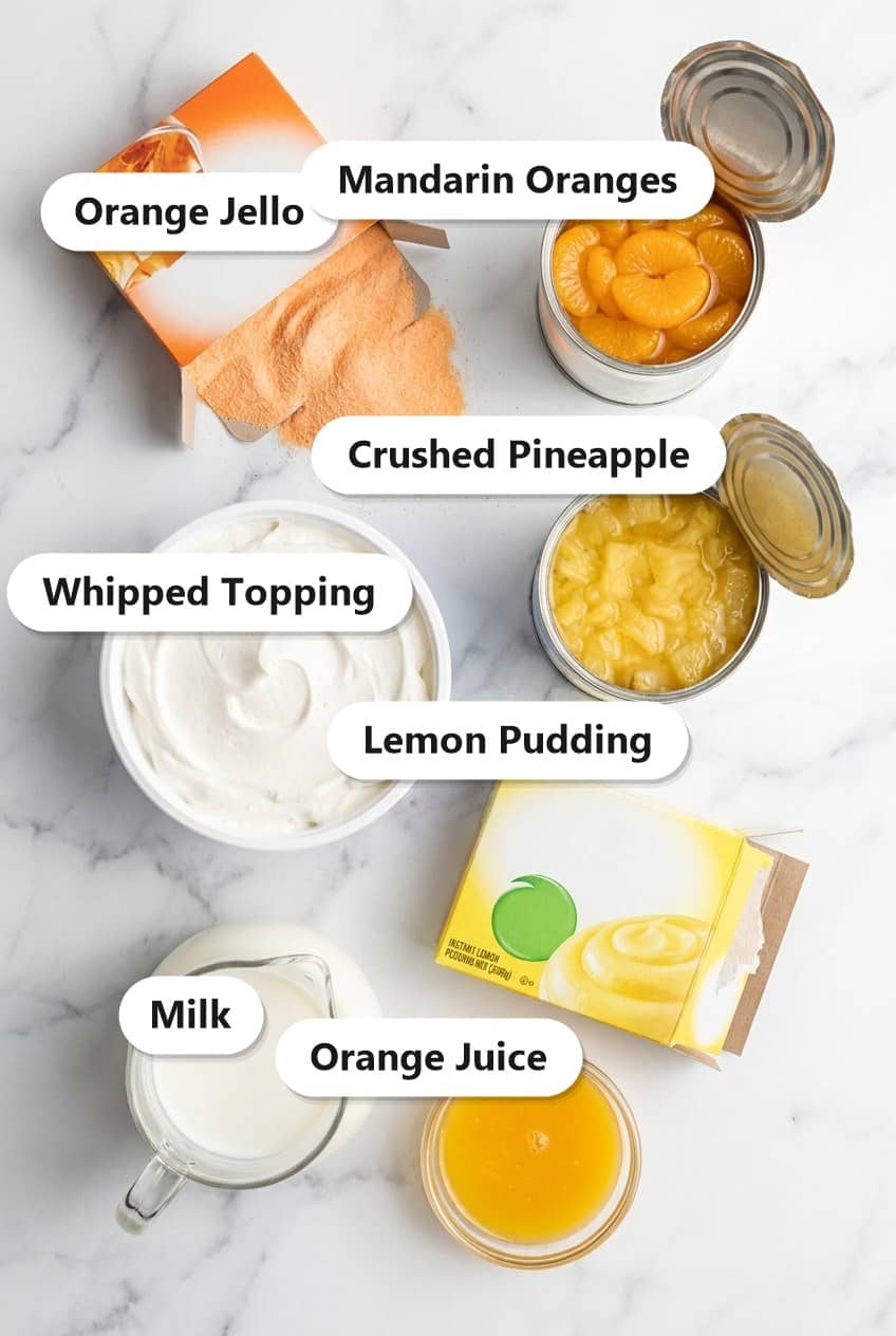Labeled ingredients to make mandarin orange salad including orange gelatin, mandarin oranges, whipped topping, crushed pineapple, lemon pudding, and milk.