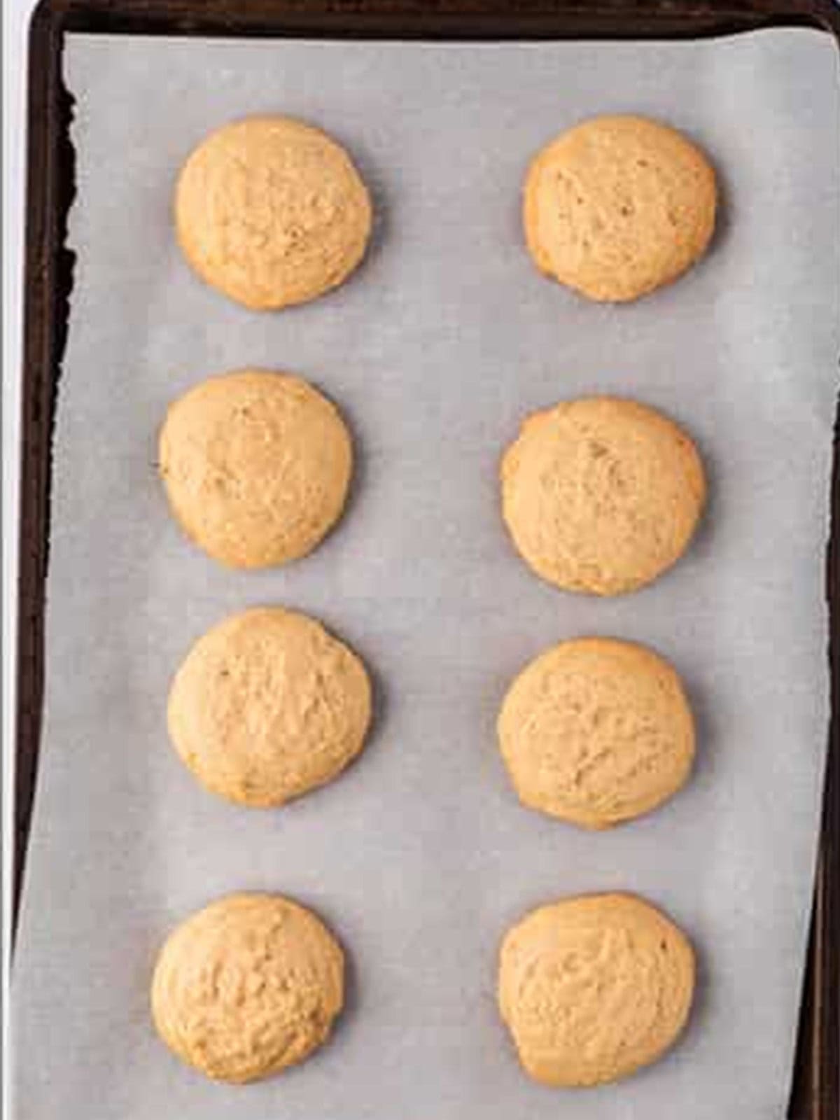 Baked maple cookies cooling on the baking sheet.