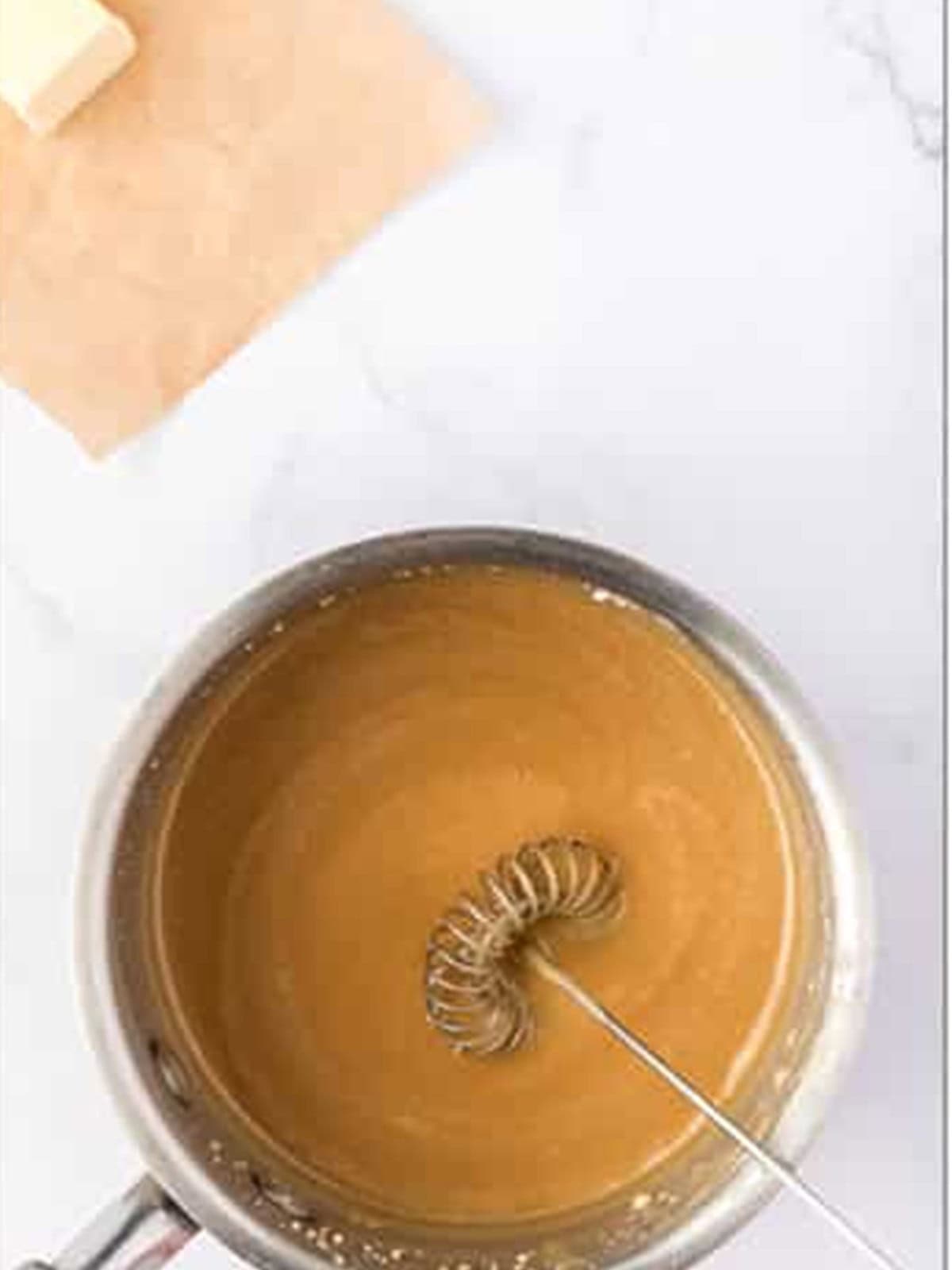 Maple icing whisked together in a saucepan for drizzling over the cookies.