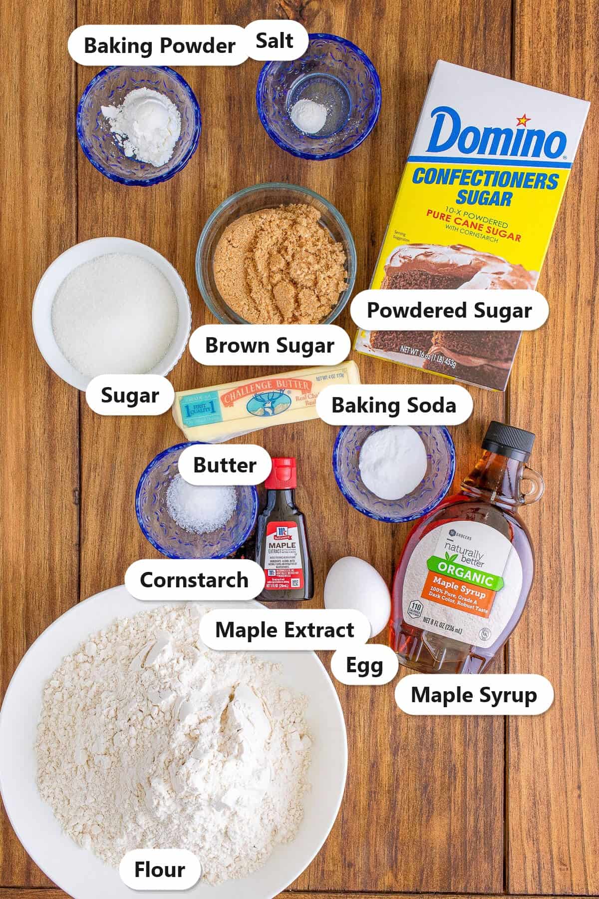 Labeled ingredients for maple cookies including flour, brown sugar, powdered sugar, butter, egg, maple syrup, maple extract, cornstarch, baking soda, baking powder, salt, and sugar.