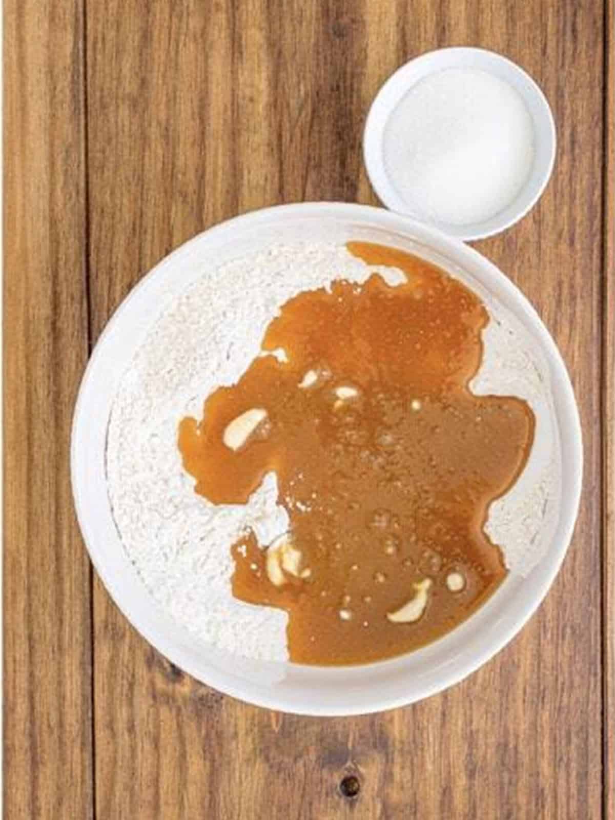 The dry flour mixture poured over the wet maple mixture in the bowl.