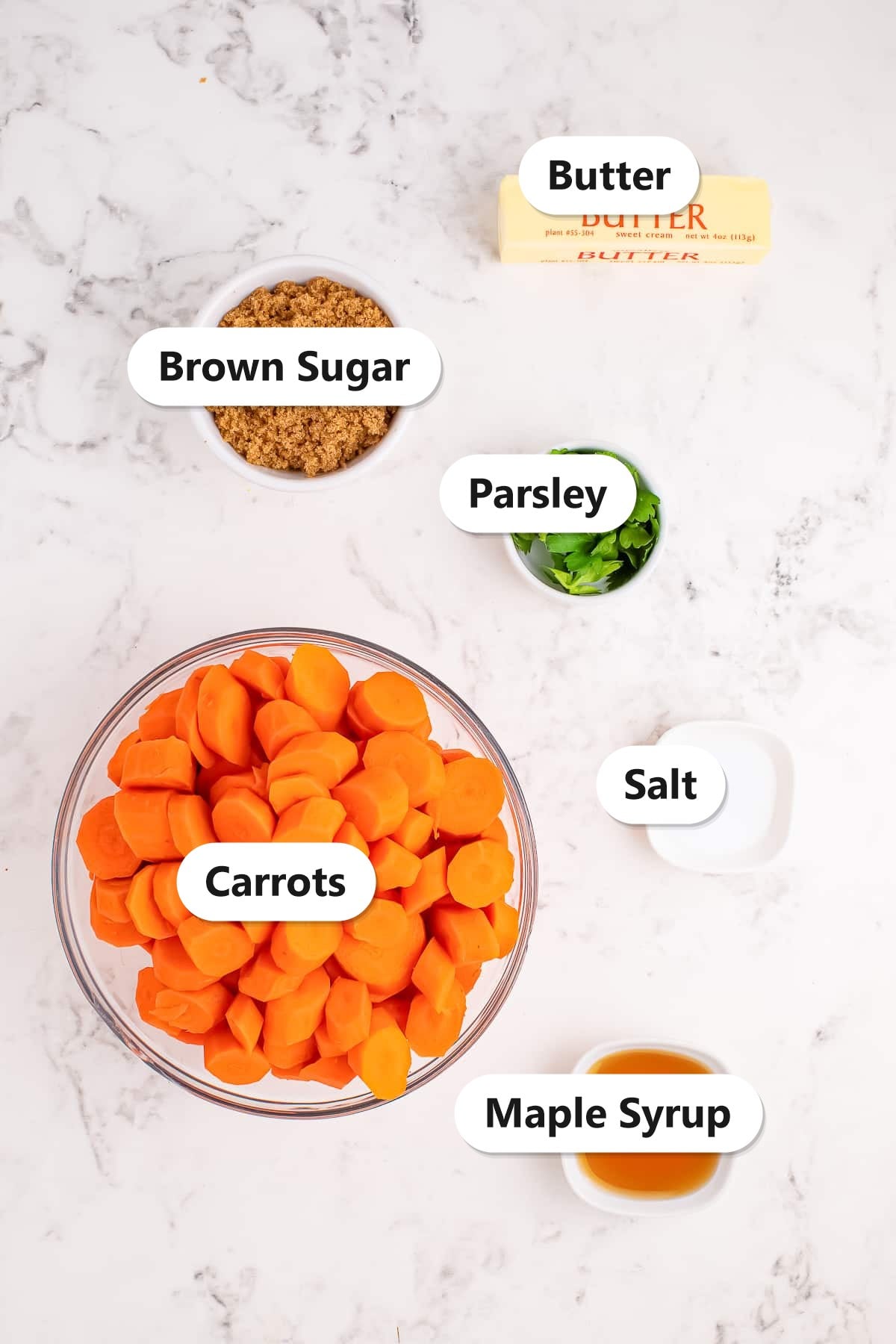 Labeled ingredients for maple glazed carrots including carrots, brown sugar, butter, maple syrup, salt, and parsley.