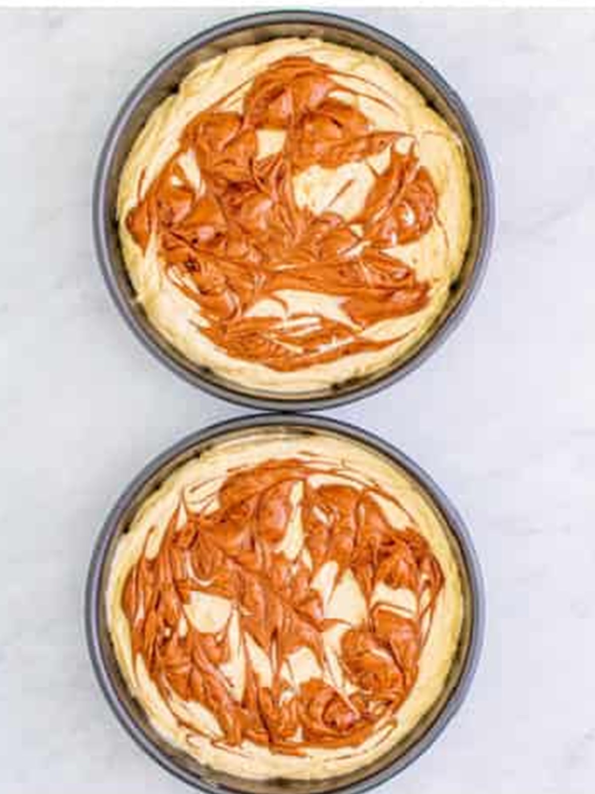 Dollops of yellow and chocolate batter swirled in cake pans