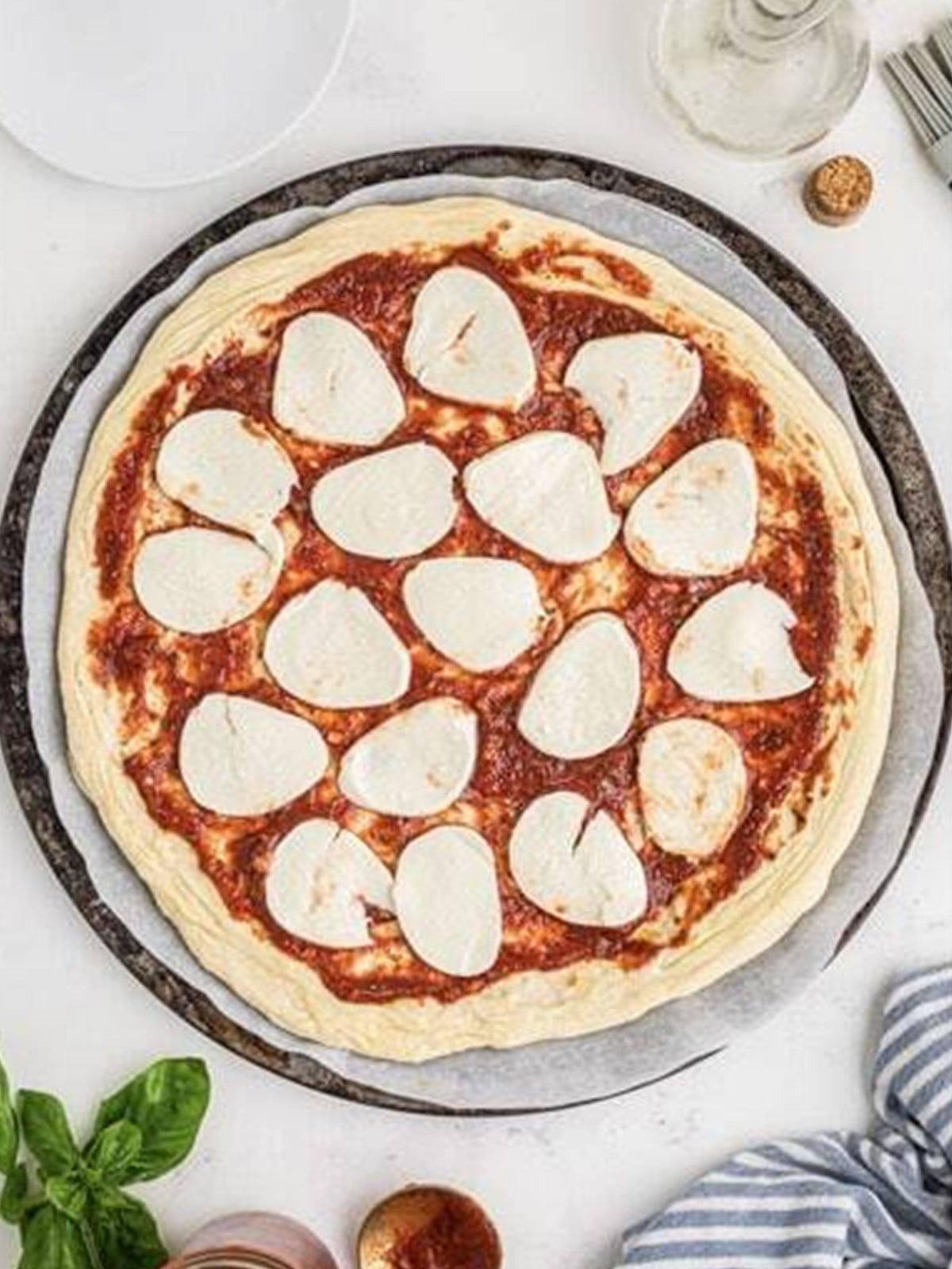 Arranging fresh mozzarella slices on margherita pizza