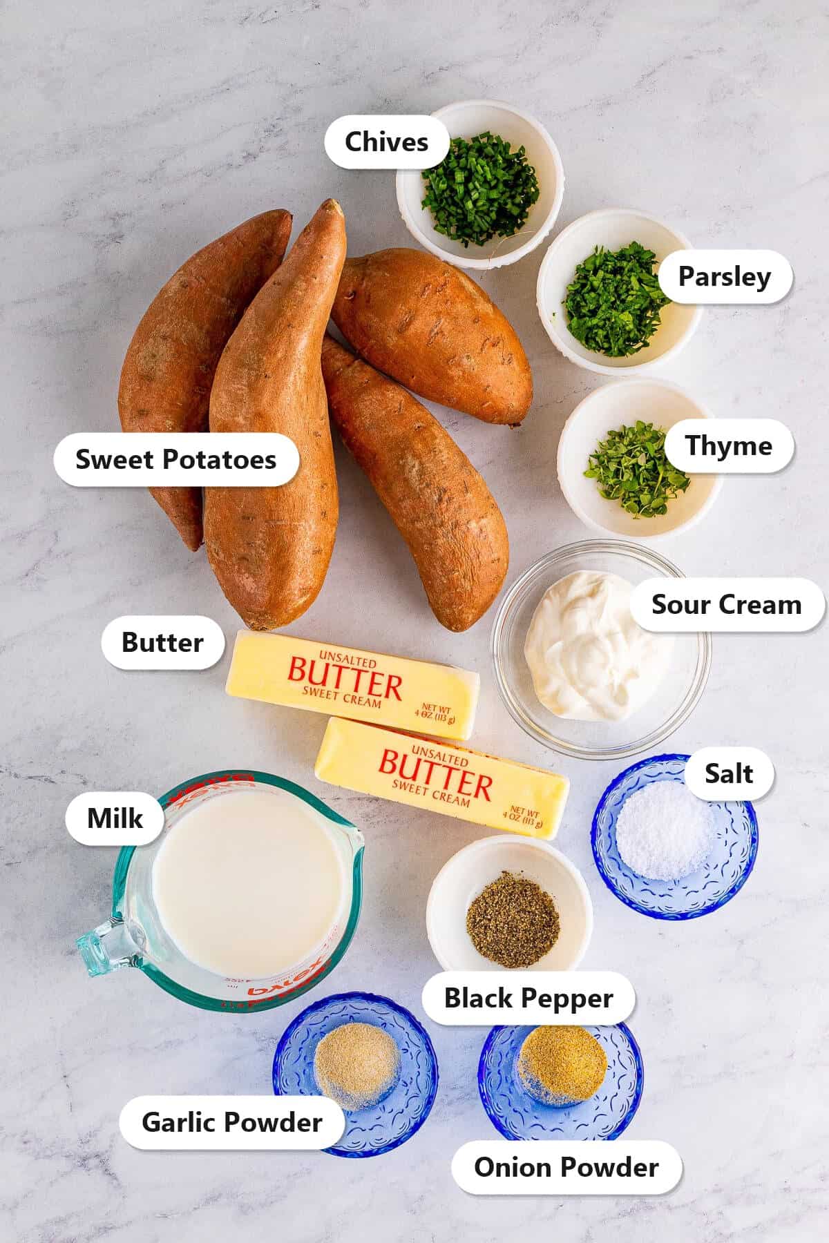 Labeled ingredients for savory mashed sweet potatoes including sweet potatoes, butter, milk, sour cream, chives, parsley, thyme, salt, pepper, garlic powder, and onion powder.