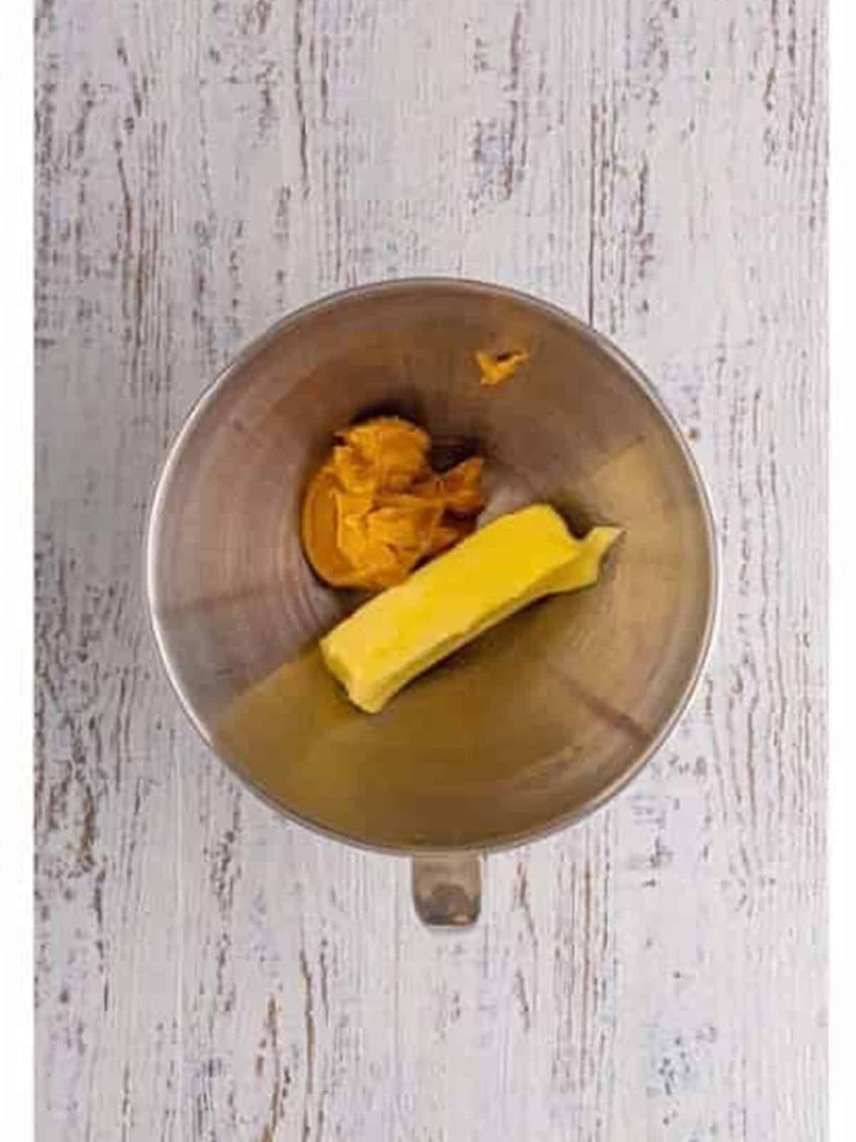 Butter and peanut butter being creamed together in a mixing bowl.
