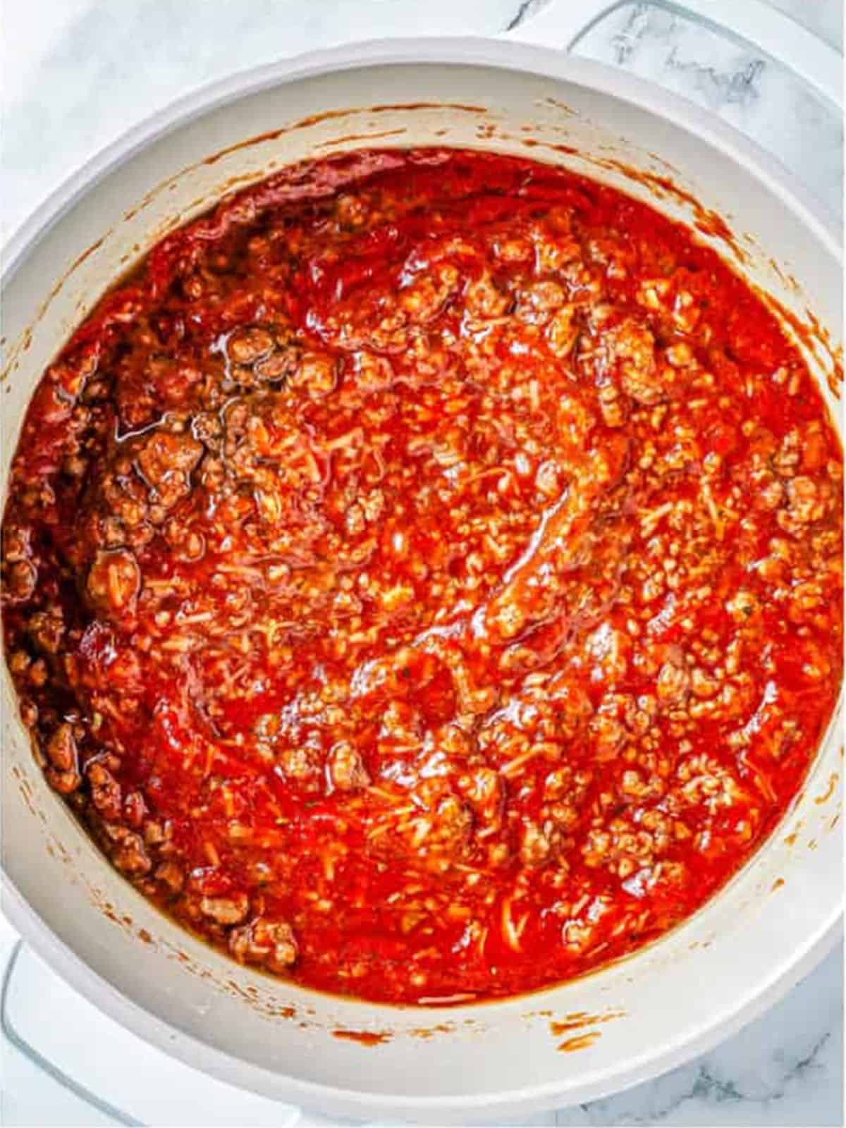Tomato sauce and paste added to the beef and simmered into a thick meat sauce.